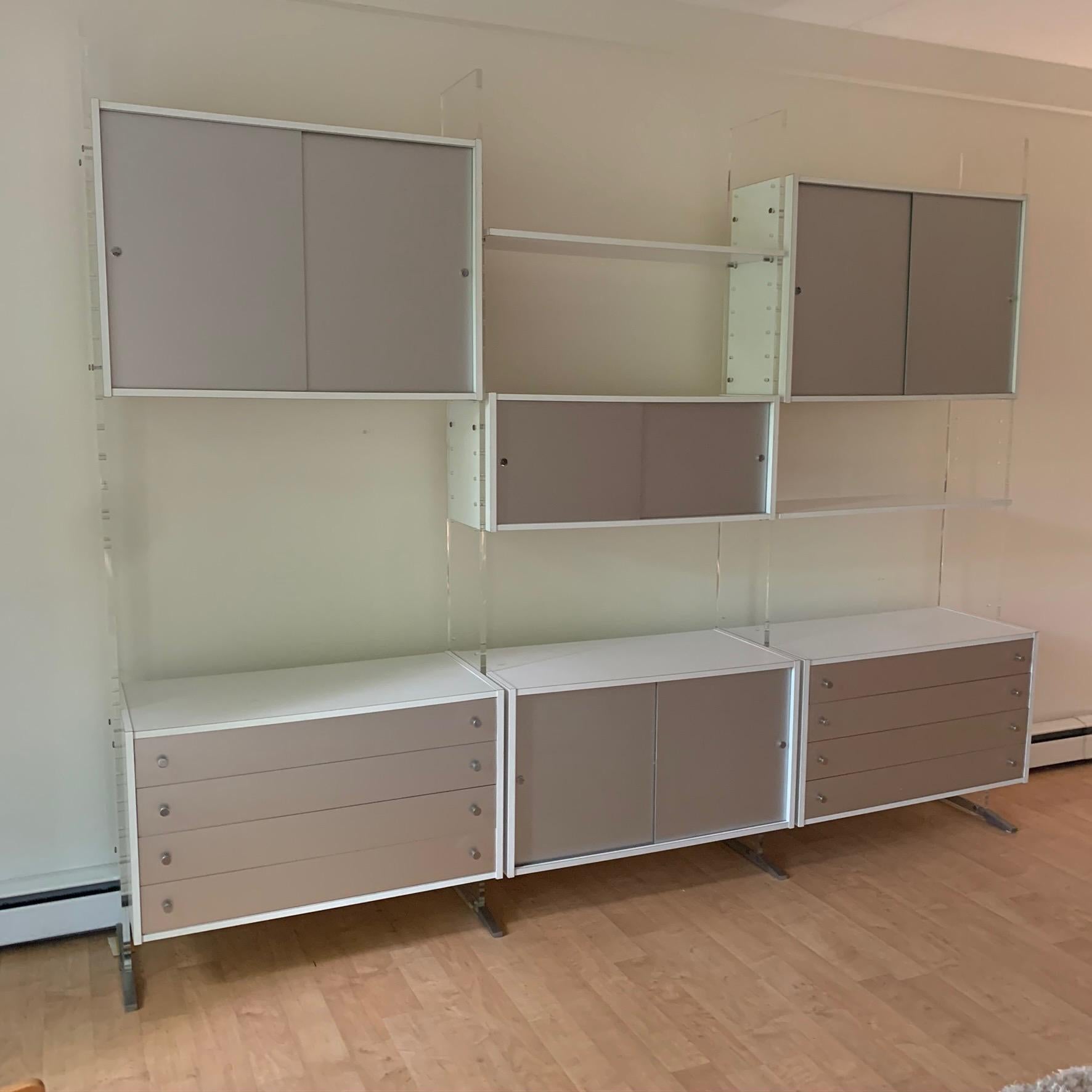 An outstanding Poul Norreklit designed wall unit for Georg Petersens Mobelfabrik from the ''Selectform'' line.The uprights are plexiglass with aluminum feet with three bays consisting of two four drawer chests, four sliding door cabinets and two