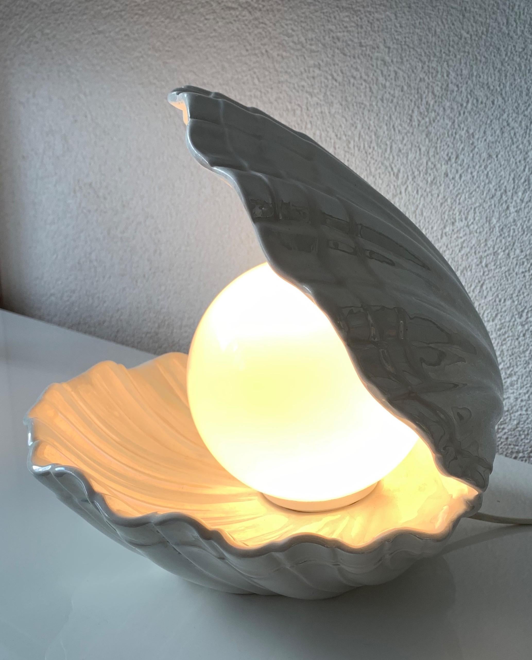 Good quality and artistic pearlescent table lamp.

If you are looking for an out of the ordinary table or night lamp then this rare specimen could be just perfect for you. This sculptural ceramic light is very realistic and its clam and pearl