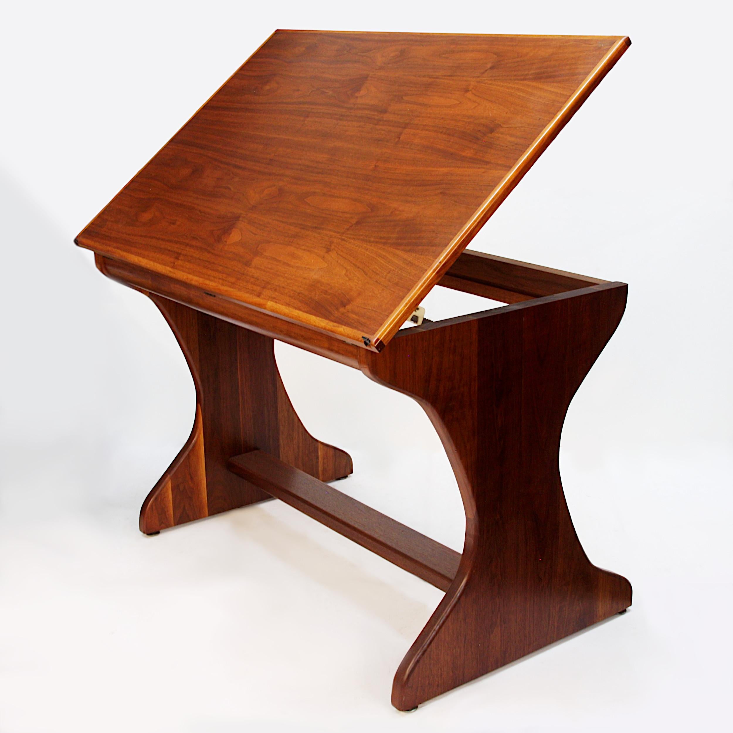 Wonderful handcrafted drafting table in the Studio Craft style. Table features a sculpted laminated walnut base with a fully-adjustable, tilting walnut-veneer top. It is not often you come across a drafting table done in the Studio-Craft style and