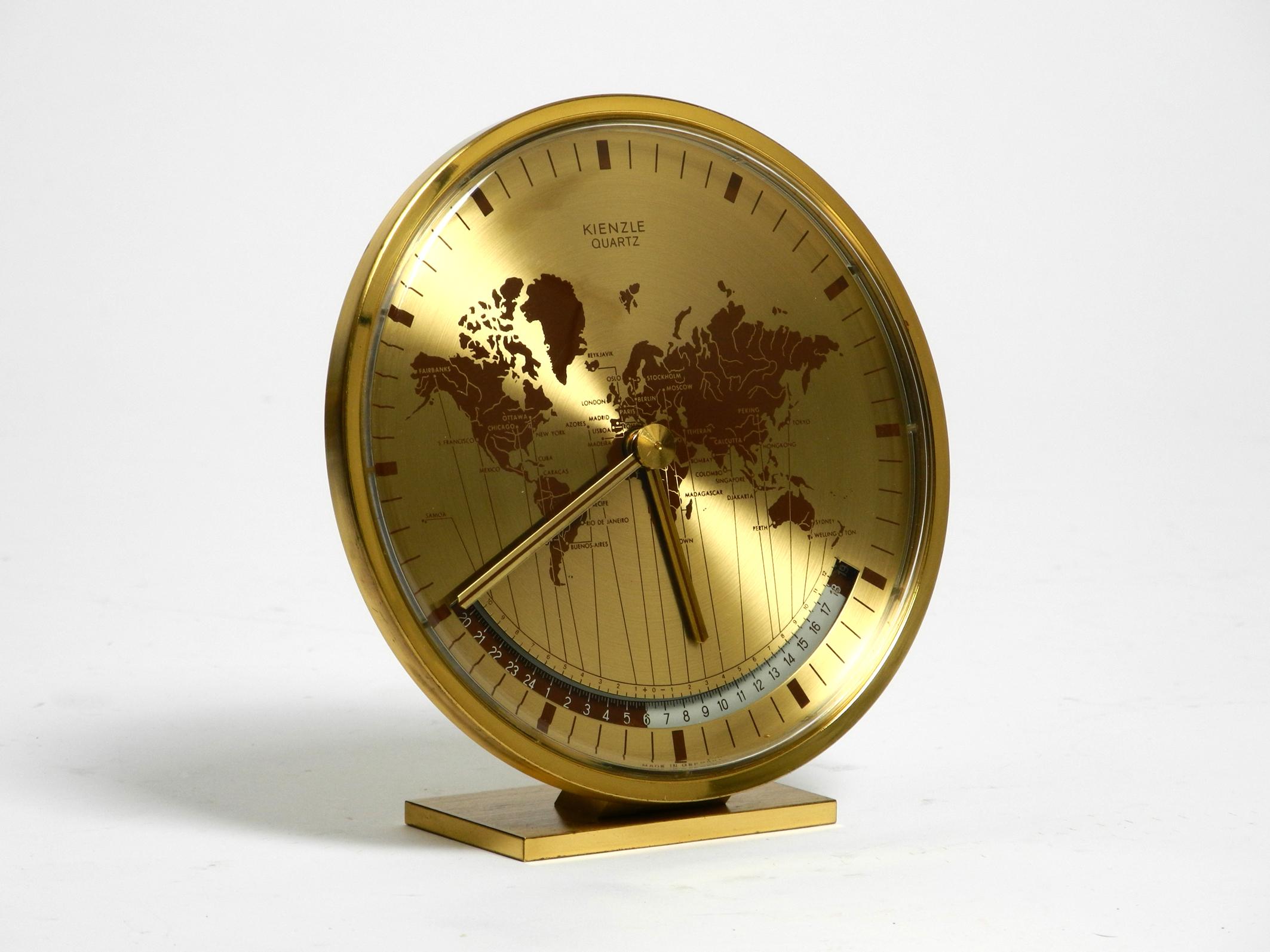 Rare 1980s brass world time table clock by Kienzle.
Goes back to the design of Heinrich Johannes Möller. Made in Germany.
Kienzle is the oldest clock company in Germany.
Housing is made of anodized metal with golden finish, brass base.
Great