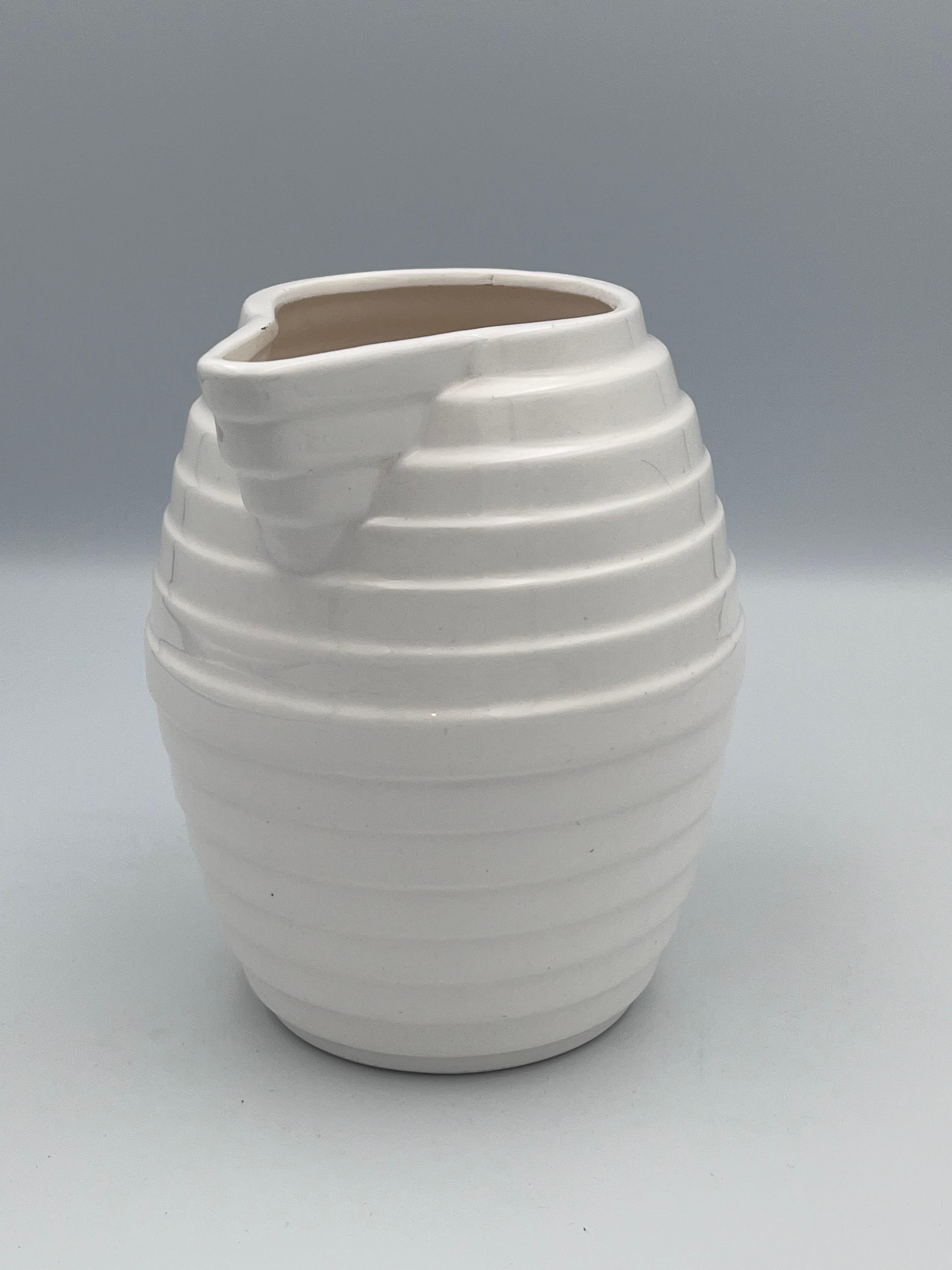 1980s Memphis Style Ceramic Pitcher – White with Black Handle, by Mann Manhattan

This striking 1980s ceramic pitcher embodies the bold, sculptural spirit of both the Memphis design movement and Art Deco revival styles of the late 20th century.