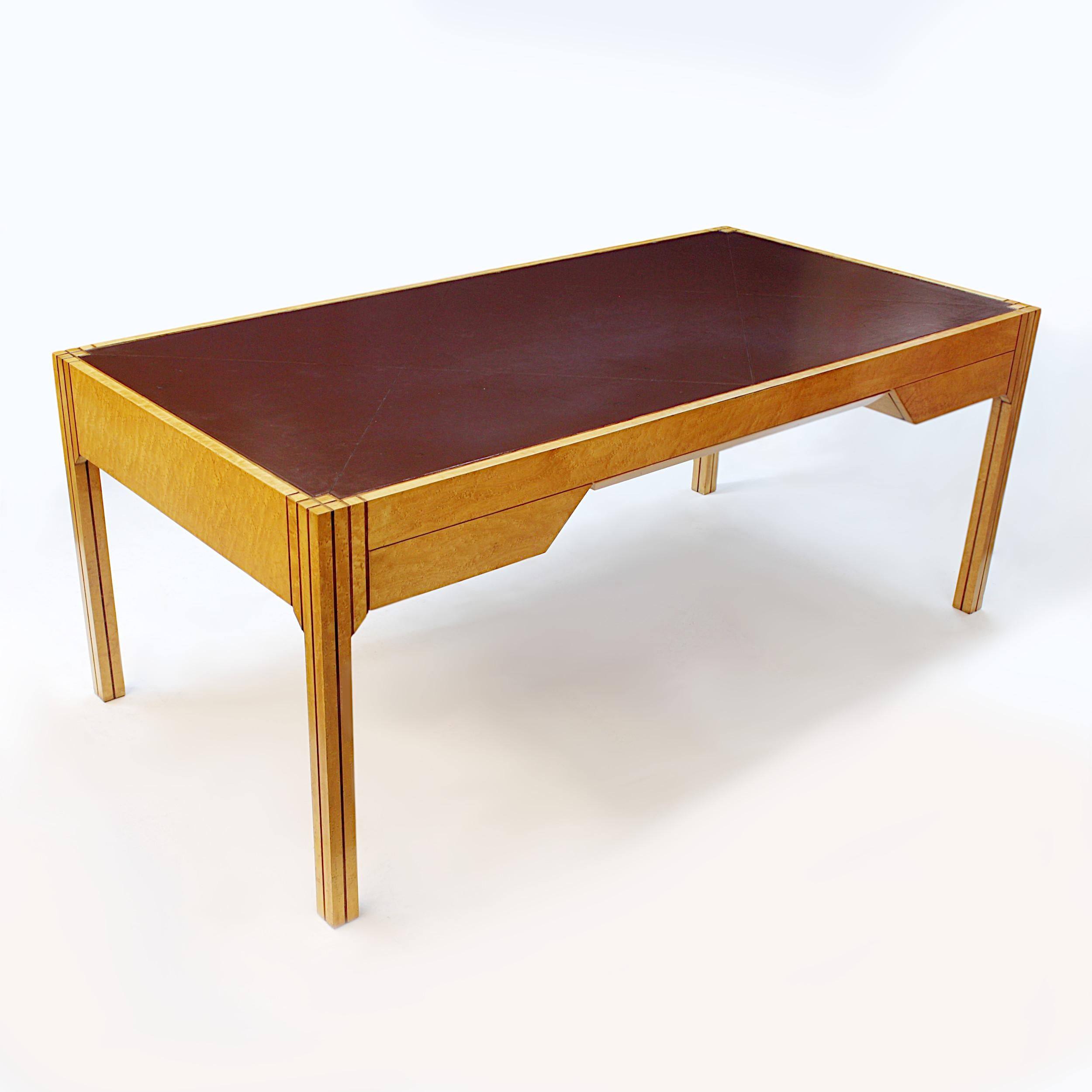 Rare Art Deco executive desk designed in 1984 by Pierre Paulin for Baker Furniture. Desk features bird's-eye maple with walnut inlays, chocolate-brown, leather-top writing surface and unique Art Deco Revival lines. This desk was based on a desk