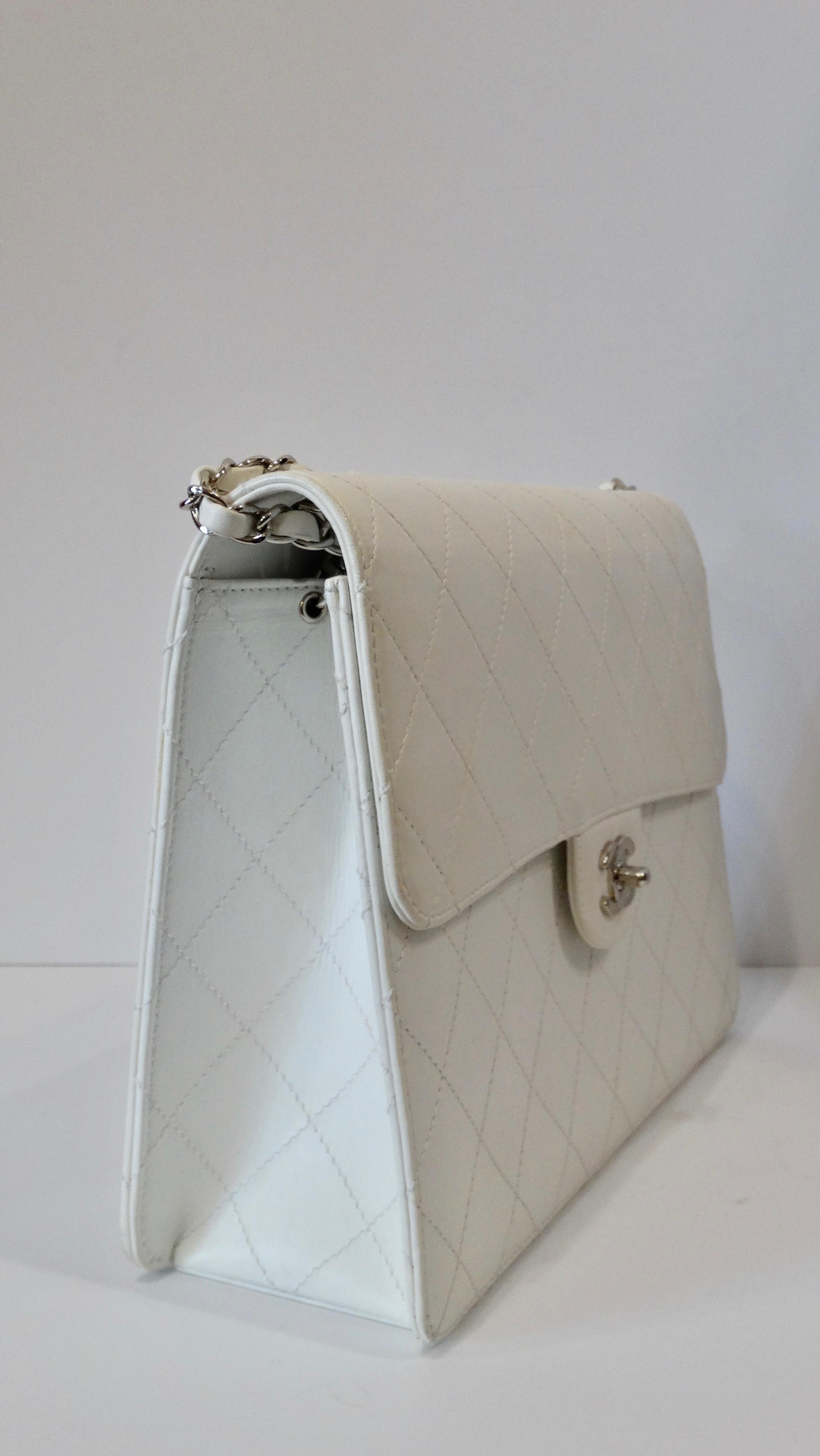 Carry around a rare piece of vintage history courtesy of Karl Lagerfeld! Circa late 1990s, this large Chanel shoulder bag is made of soft opaque white goatskin leather and is stitched with Chanel's signature quilting pattern. Features silver plated