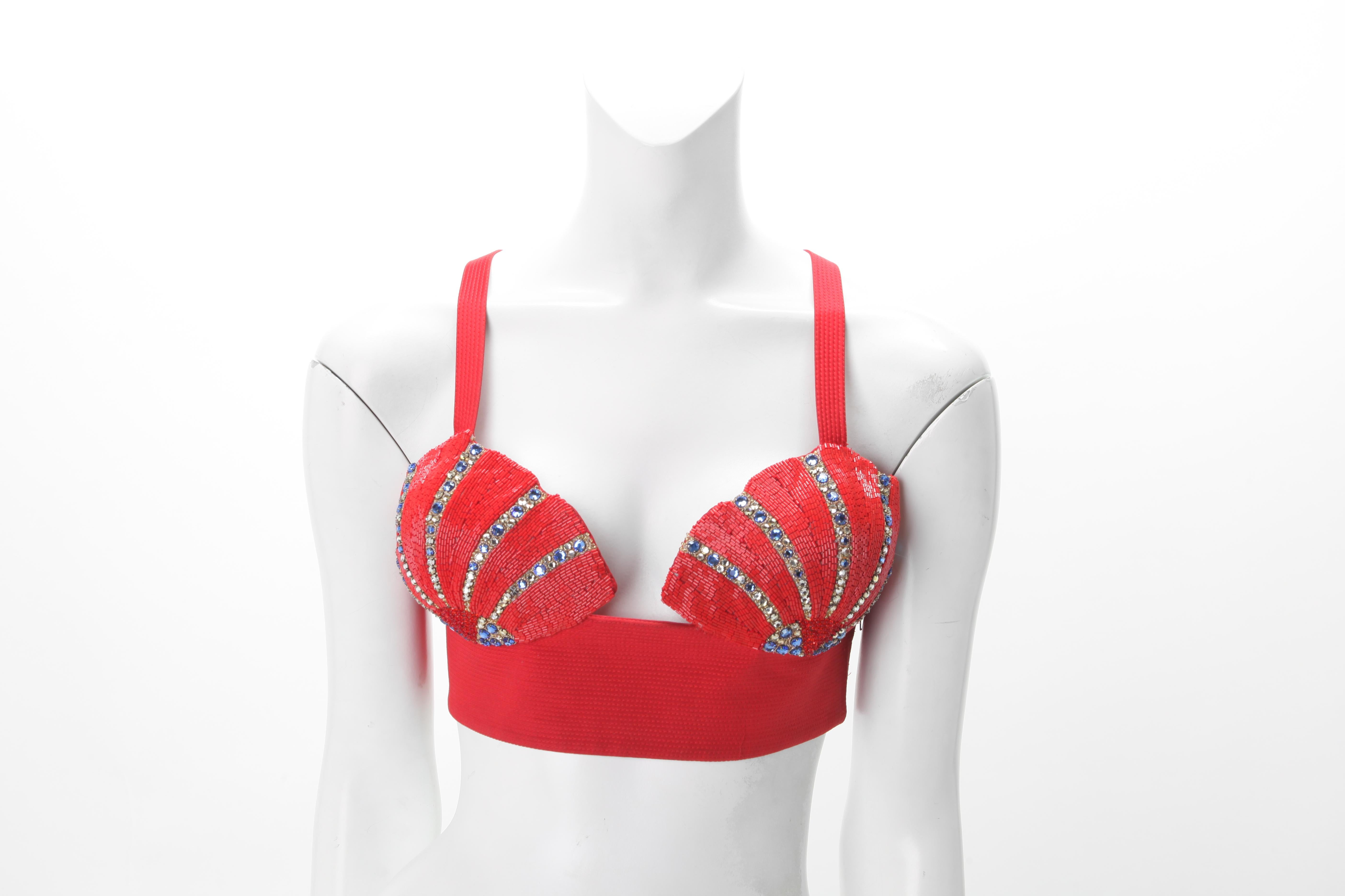 Rare 1991 Gianni Versace Embroidered Shell Buster. Shell cups densely embroidered with red bugle beads; cobalt and clear rhinestone striations ; Ribbed Silk Panel. Zipper closure at side.