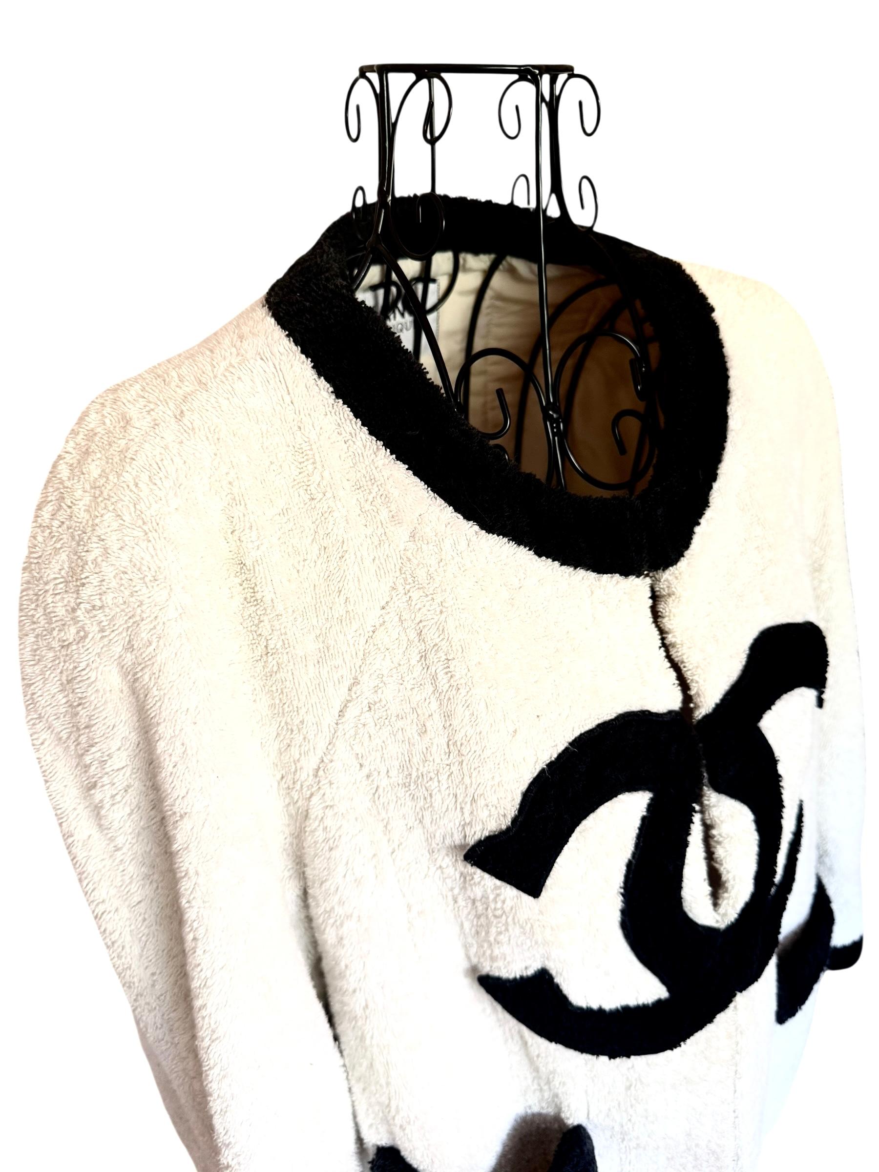 Diese ikonische Chanel-Jacke stammt aus der Herbst/Winter-Kollektion 1992 und wurde von Supermodel Christy Turlington getragen. Das Modell stammt aus Karl Lagerfelds Ära der kühnen Logos und zeigt ein übergroßes, schwarzes, ineinandergreifendes