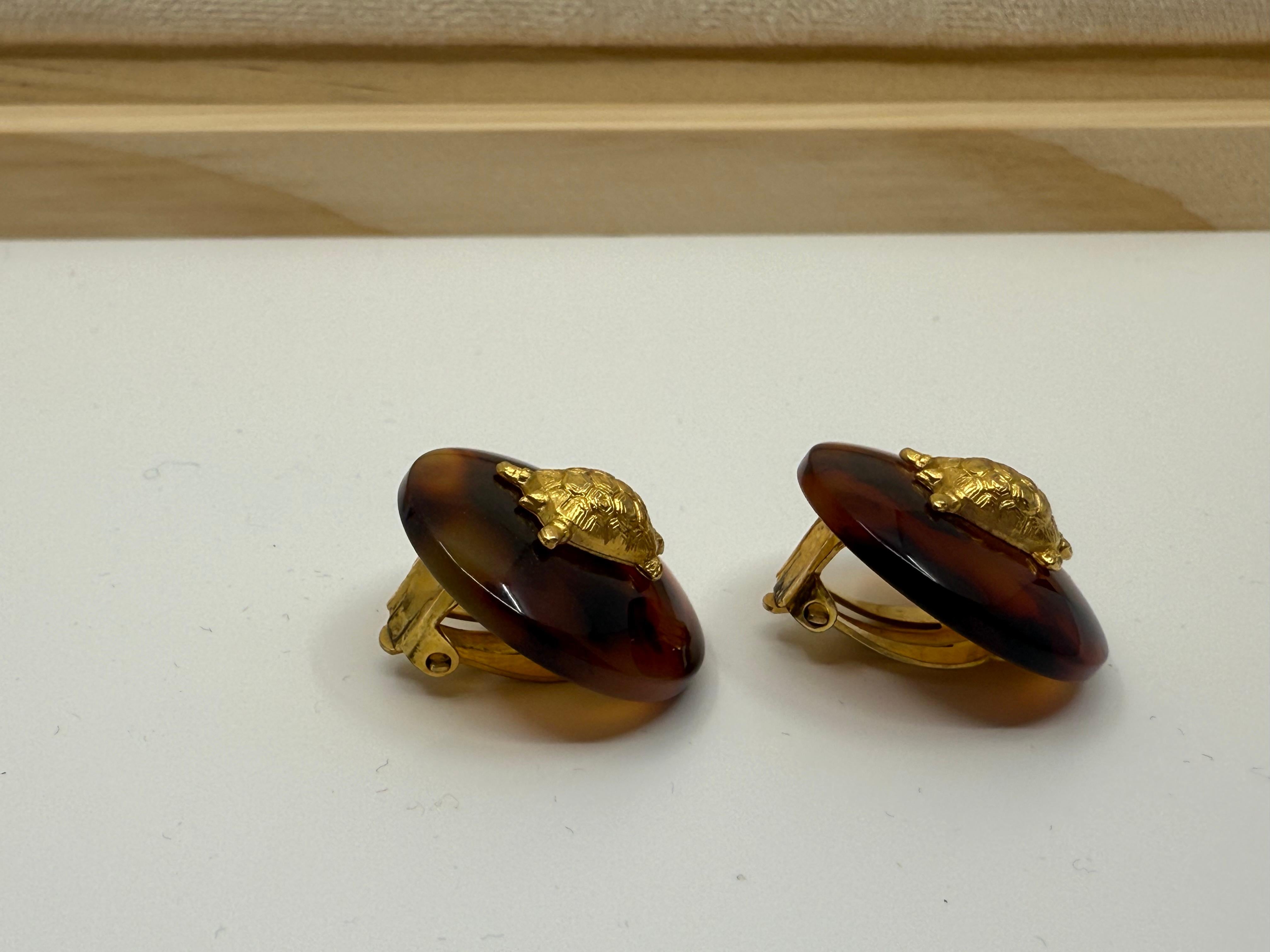 Issues de la collection fantaisiste de Chanel en 1997, ces boucles d'oreilles vintage à clip sont une pièce rare et ludique. Conçu dans une résine chaude en fausse écaille, chaque disque circulaire est orné d'une charmante tortue dorée, un motif