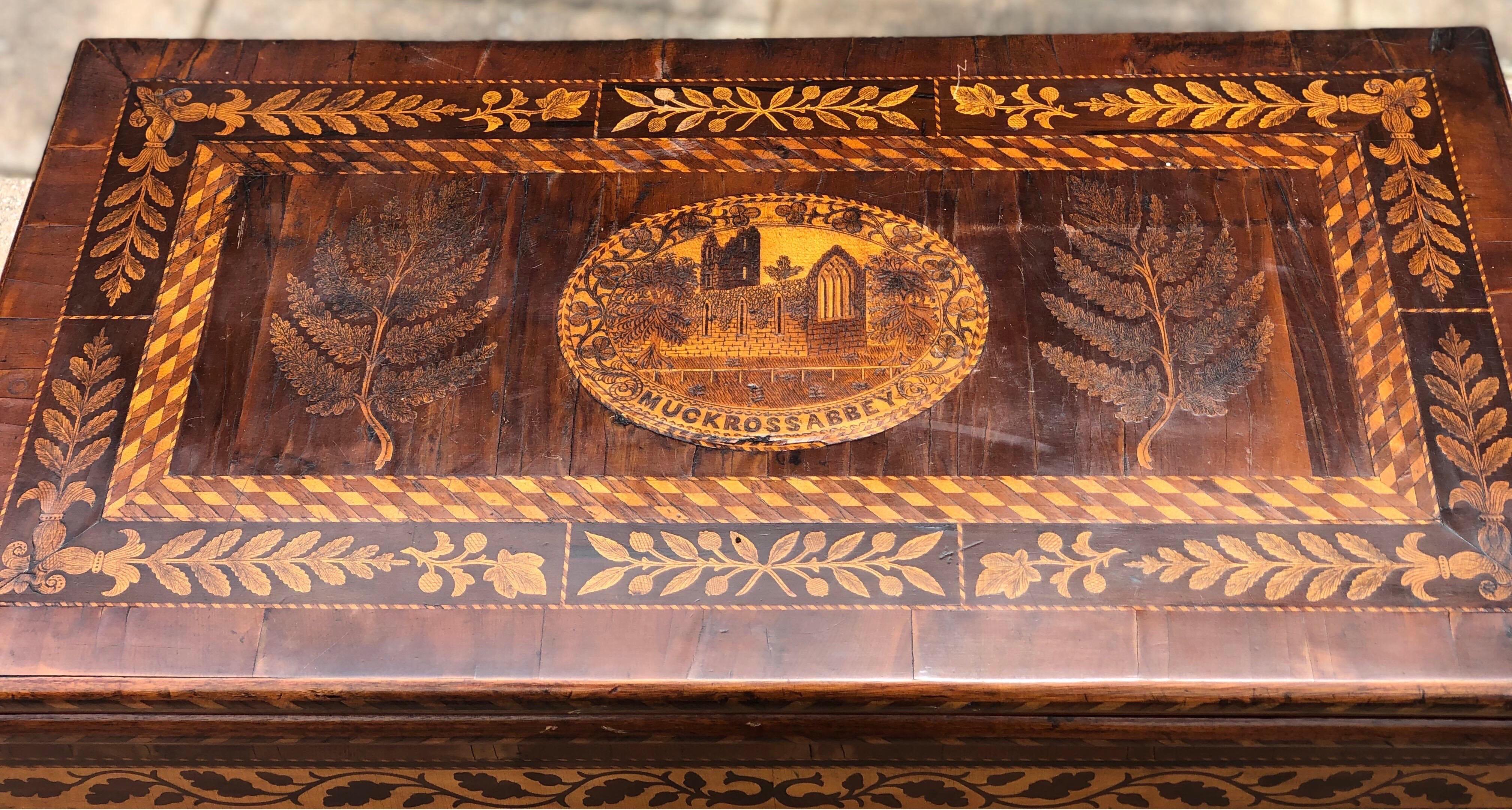 19th century Killarney games table with depictions of Muckross Abbey, shamrocks, ferns and acorns throughout. 

The furniture from this part of Ireland is very distinctive with inlaid scenes and symbols of Ireland. The top has a scene of Muckross