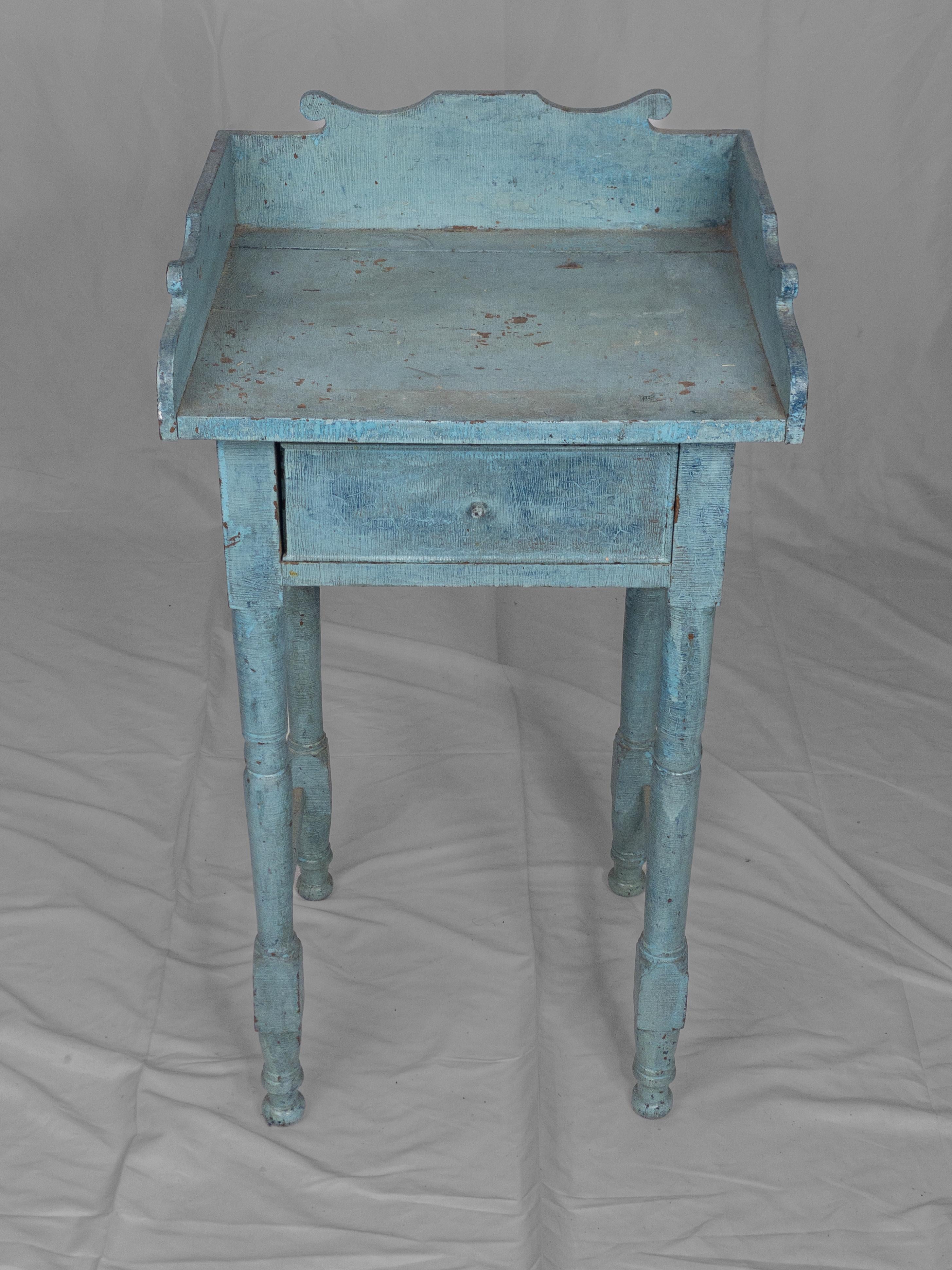 The Rare 19th Century American Painted Wooden Side Stand is a captivating piece of antique furniture with historical significance. Painted in a delicate baby blue hue, this color choice reflects the aesthetics of the 19th century and adds a