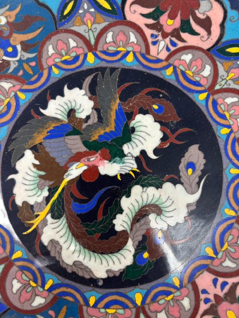 This exquisite piece is crafted with great care and beauty. It features a stunning dragon scene and is marked at the base.

Cloisonné, the enameling technique employed in this piece, involves using fine wires to outline decorative areas (referred to