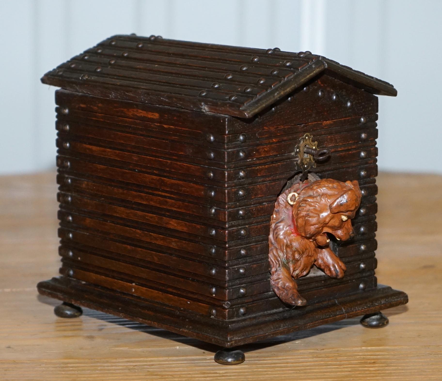 We are delighted to offer for sale this stunning original circa 1870 Black forest wood carved cigar box humidor in the form of a dog kennel

A good looking master craftsman carved cigar box complete with the original key and very angry dog