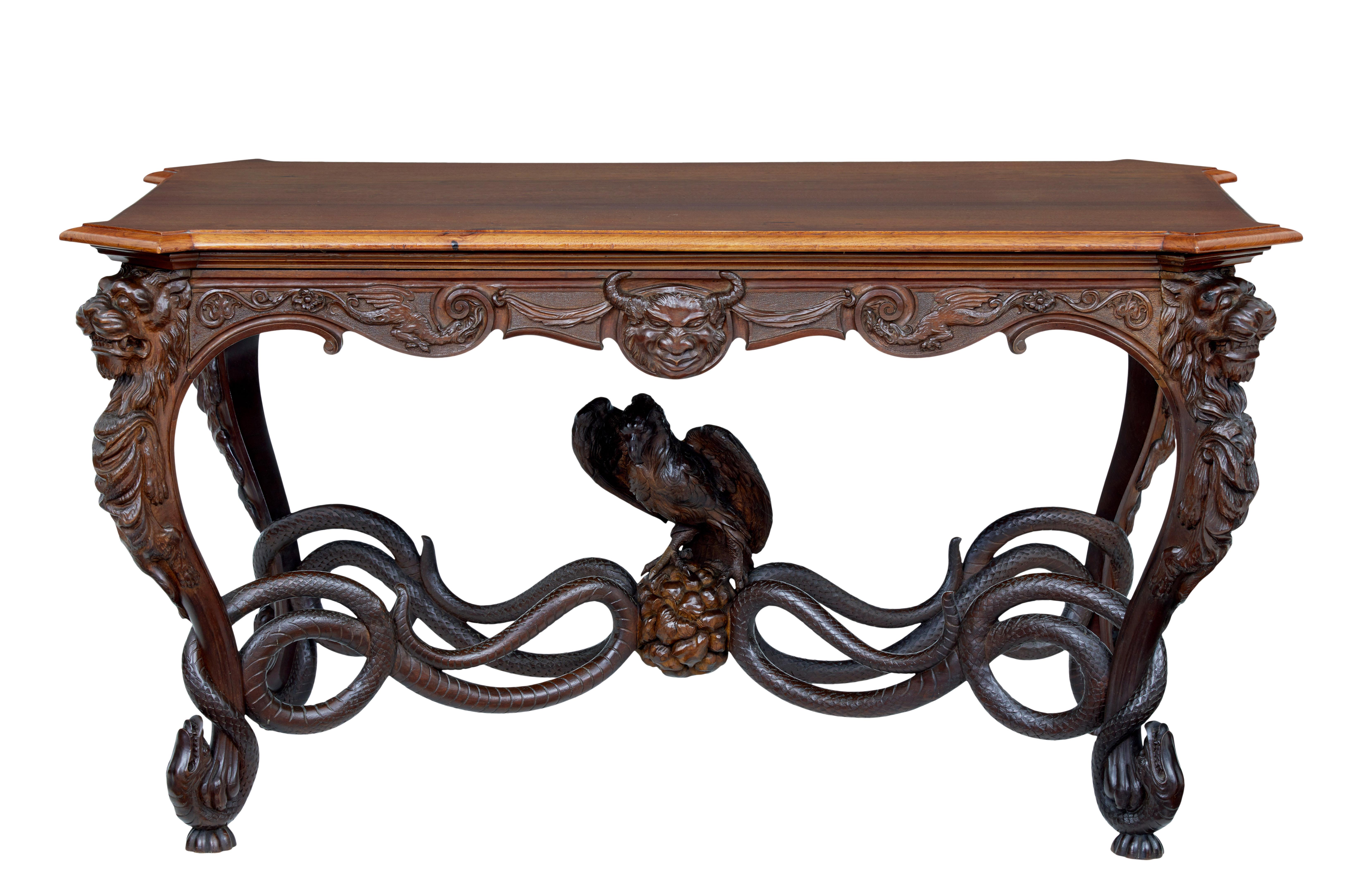 Rare and fantastic profusely carved mahogany table, circa 1870.

Simple mahogany top with canted corners but this table is all about the base. Carved devils to each frieze with swags and scrolls. Carved beast heads to the top of the legs which