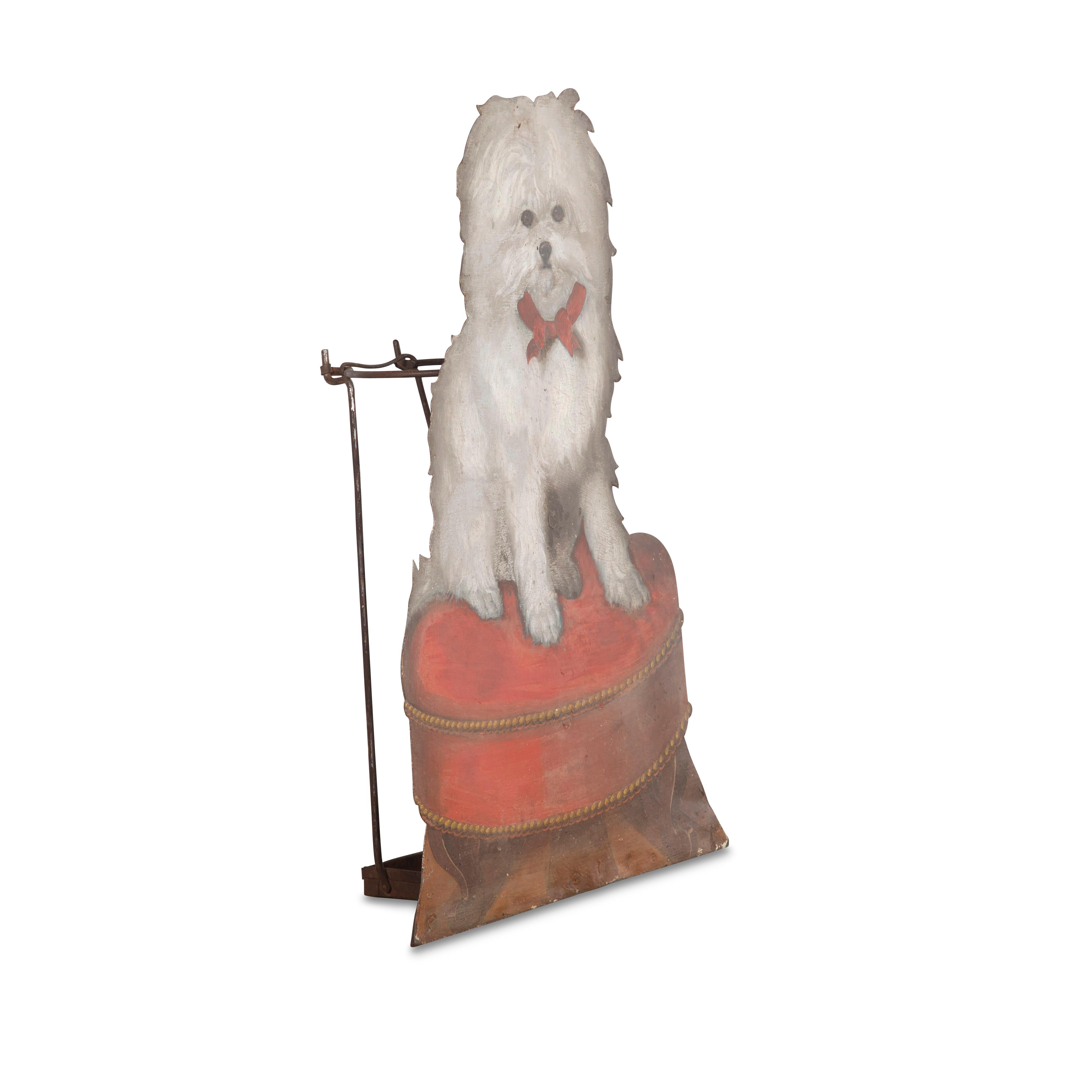 A rare C19th decorated tole dummy board constructed as stick stand, depicting a terrier with red ribbon collar, seated upon a red velvet cushion stool with small cabriole legs and parquetry floor below. A visually charming article of what was