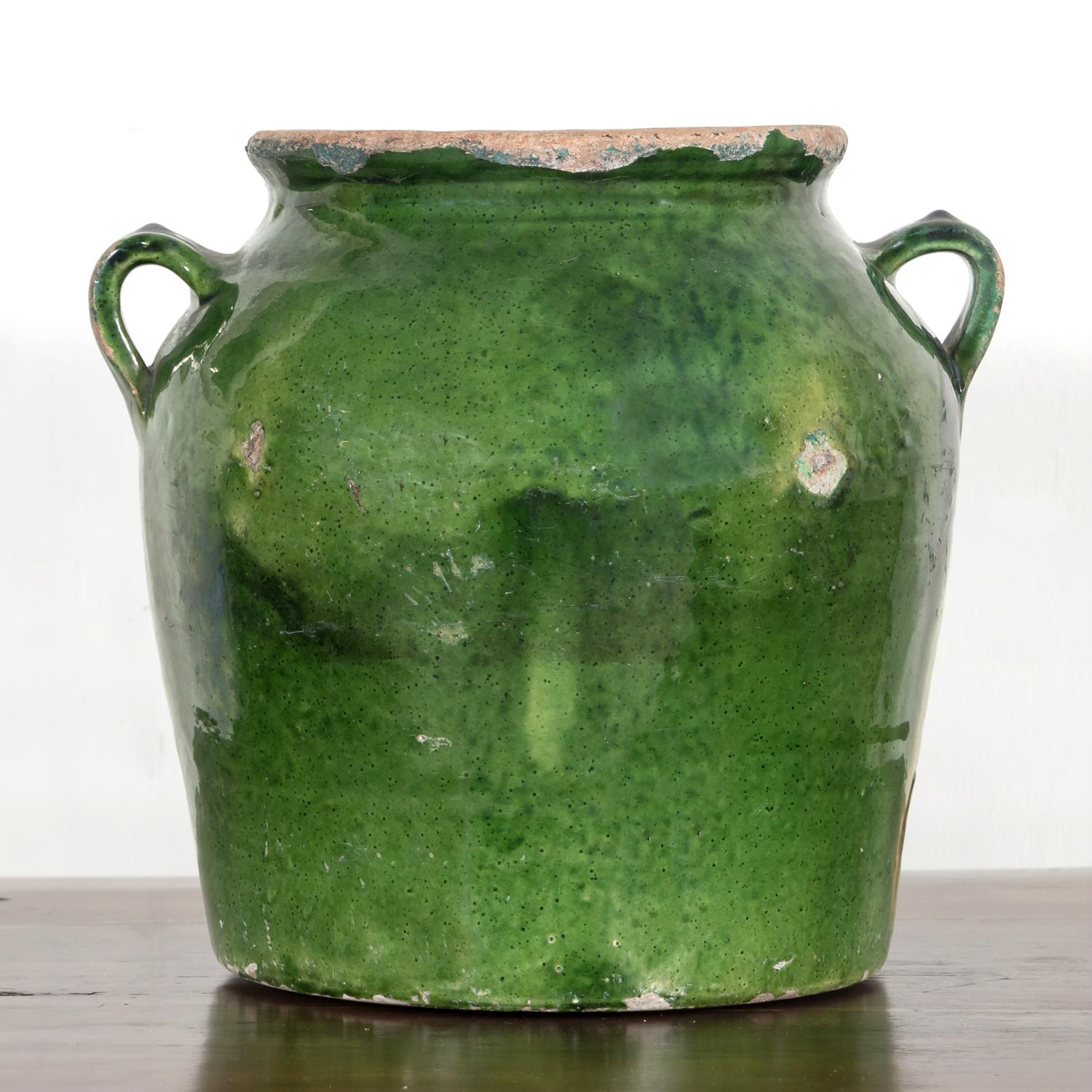 A stunning 19th century French pot de confit or confit pot from southwest France having two handles and a rare dark green glaze on the outside with a yellow glaze inside the pot, circa 1880s. Utilitarian earthenware vessels like this one were a