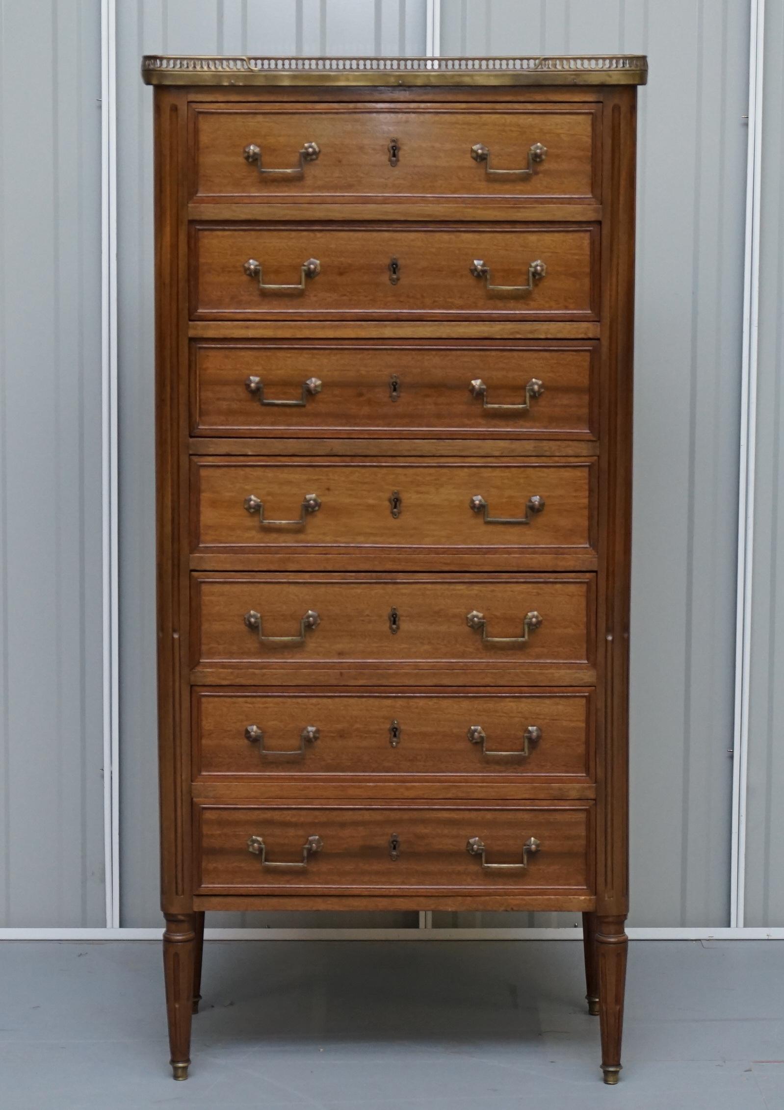 We are delighted to this very rare and extremely good looking French 19th century mahogany with marble top and brass gallery rail Semainier lingerie chest of drawers

This French 19th century Louis XVI-style seminar, or lingerie chest, circa 1880,