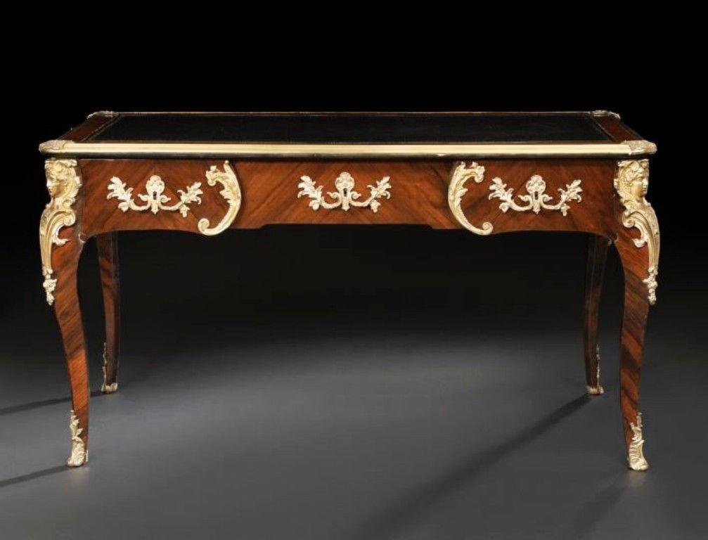L'article que nous vous proposons est un exceptionnel bureau à tiroir en bois de roi Louis XV du 19e siècle, de qualité muséale. Le plateau rectangulaire arrondi est orné d'un bandeau en bronze doré et d'une surface en cuir insérée, au-dessus d'une