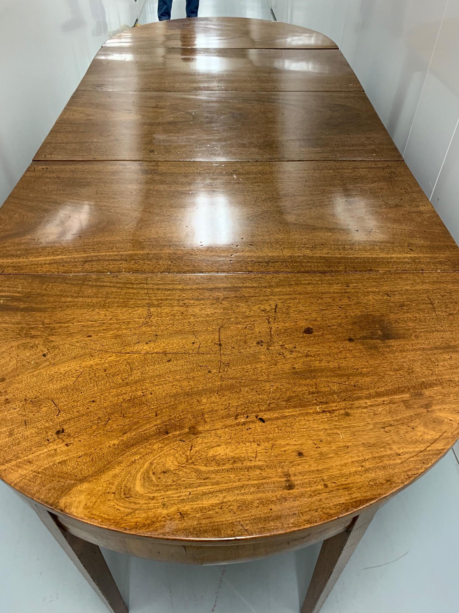 A gorgeous extremely versatile 19th century mahogany Hepplewhite dining table that is a roomy 8 1/2 feet when fully extended. The table is a wonderful design with two beautiful removable demilunes that are added at each end for extension purposes.