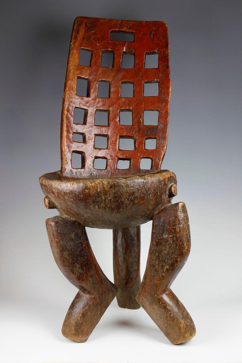 This amazing nineteenth-century high-backed chair, from the Gurage culture in Ethiopia, has many unusual characteristics. The solid, bowl-shaped seat of the chair is supported by three legs, which bow inwards before veering outwards as they reach
