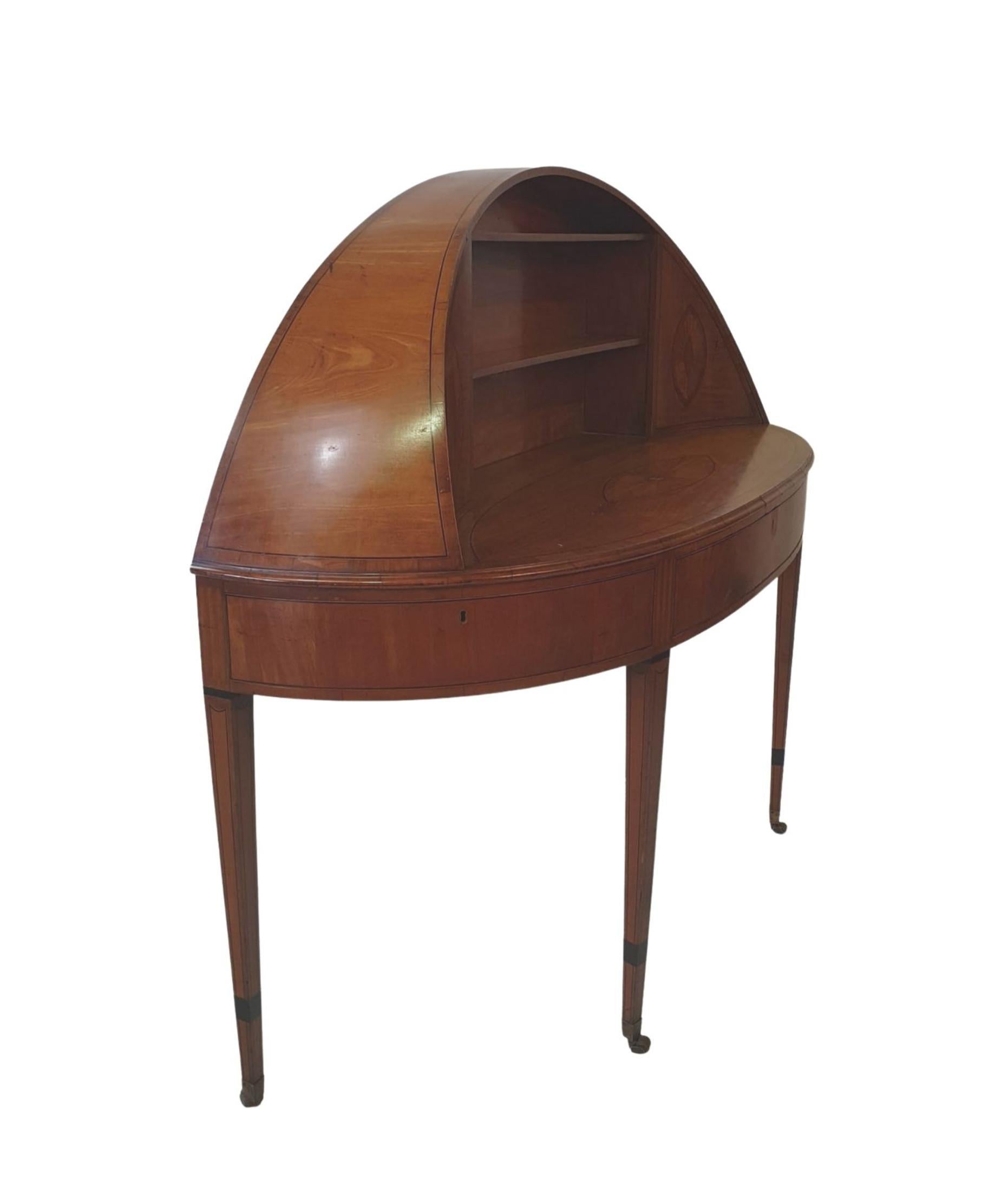 This exceptional Carlton House desk with unusual dome shaped top with three fit-ted shelves flanked with two inlaid doors raised above shaped and moulded inlaid desk top above apron with three drawers supported on square tapering leg terminat-ing on