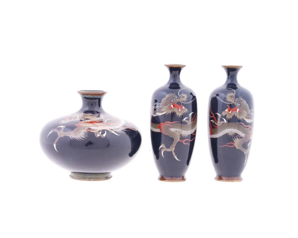 Three antique Japanese Meiji period vases, distinguished by their flared necks and decorative designs. Two of the vases feature high-shouldered forms, while the third is of a globular shape. The decoration on each vase consists of polychrome