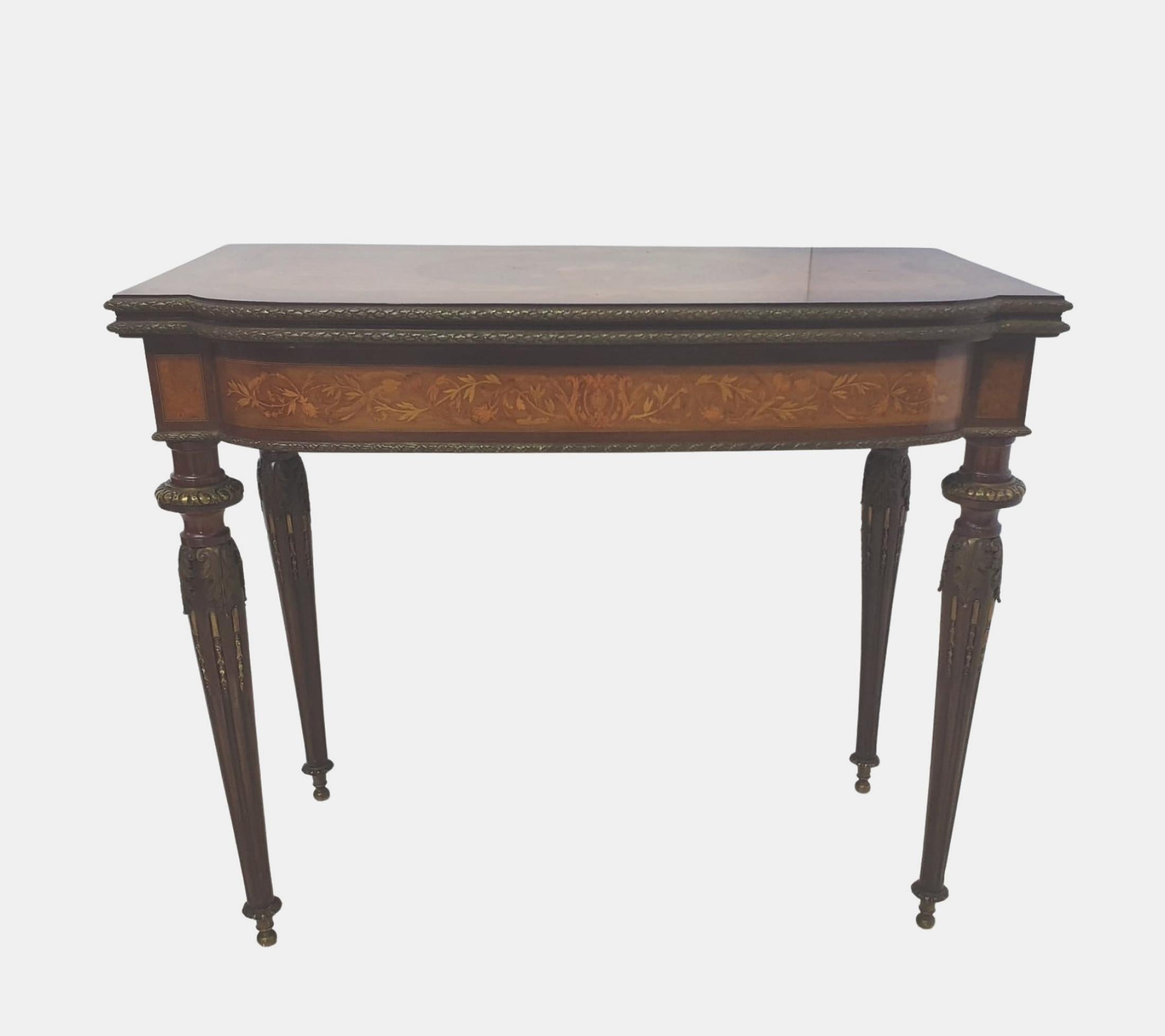 A rare museum quality 19th Century marquetry inlaid turn over leaf card table with ormolu mounts thoughout. The shaped and moulded top of rectangular form with intricate marquetry inlay centred with a cartouche depicting musical instruments and