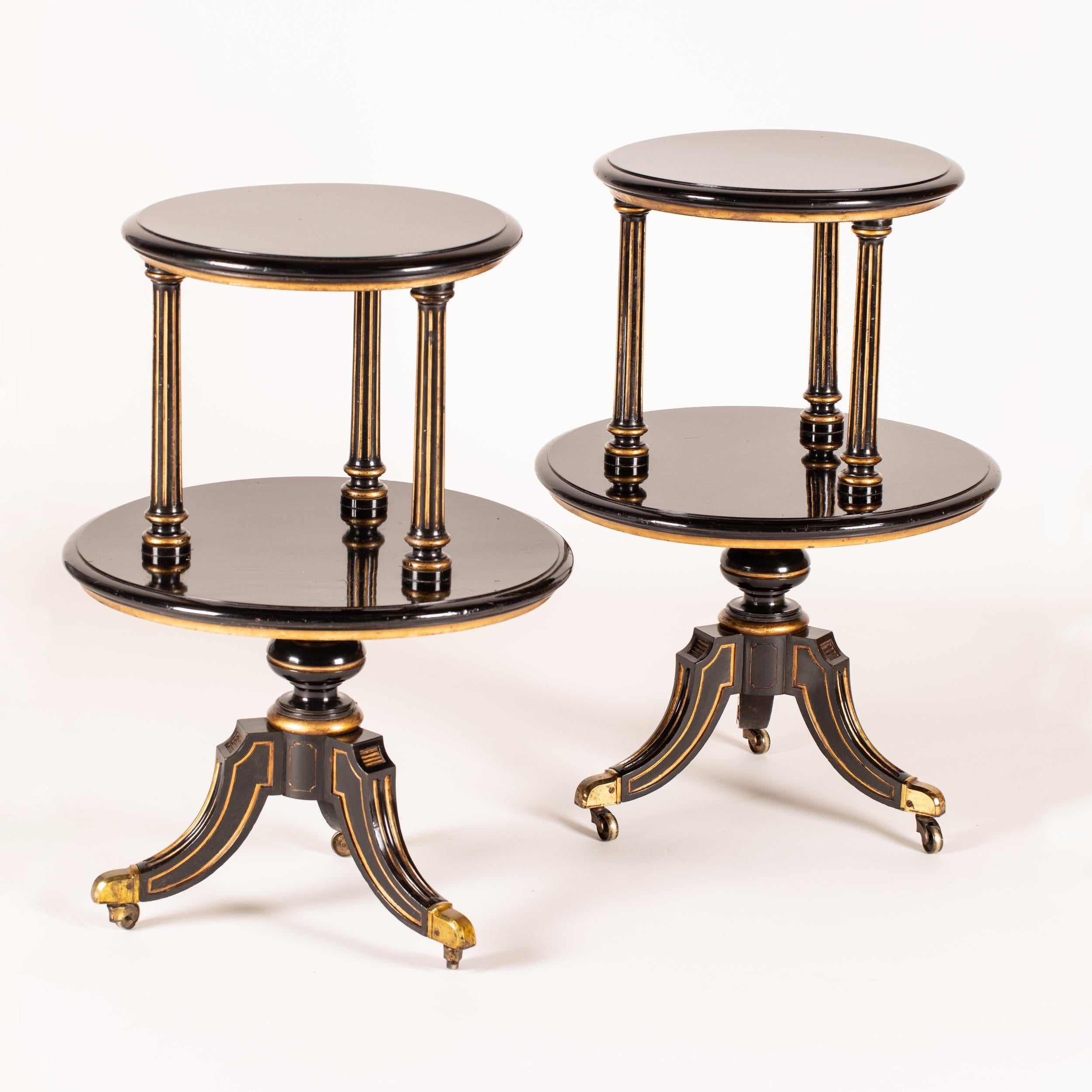 A pair of black lacquered Étagères
In the early aesthetic Manner

The circular tables having lacquered surfaces with a striking sheen, highlighted by parcel gilt details and tripartite swept legs terminating in brass castors; above, the baluster