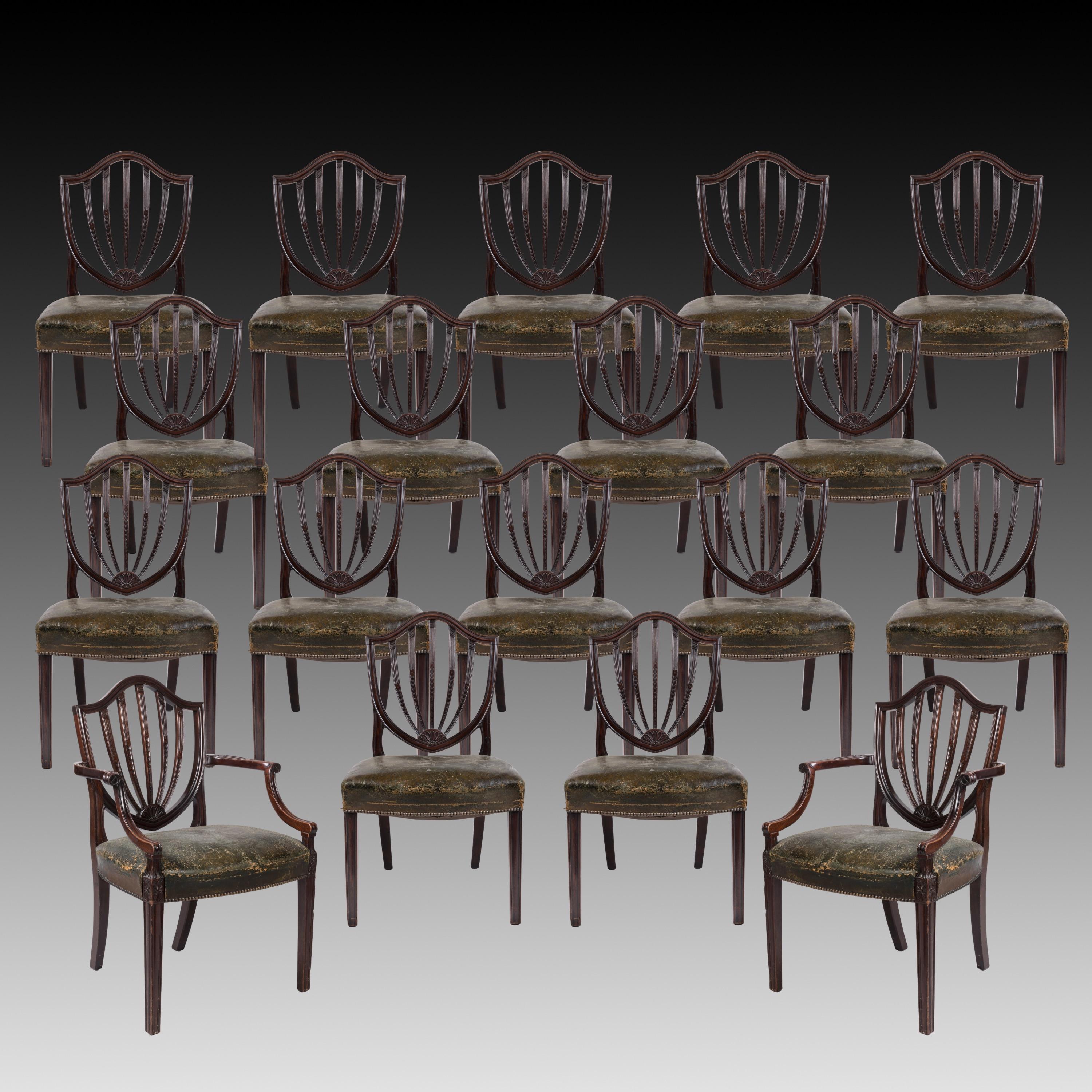 Ein Satz von zwölf Esszimmerstühlen im Stil von George III
Nach dem Entwurf von George Hepplewhite

Die aus Mahagoni geschnitzte Garnitur besteht aus zehn Stühlen und zwei Stühlen mit spitz zulaufenden Vorderbeinen und gespreizten Hinterbeinen; die