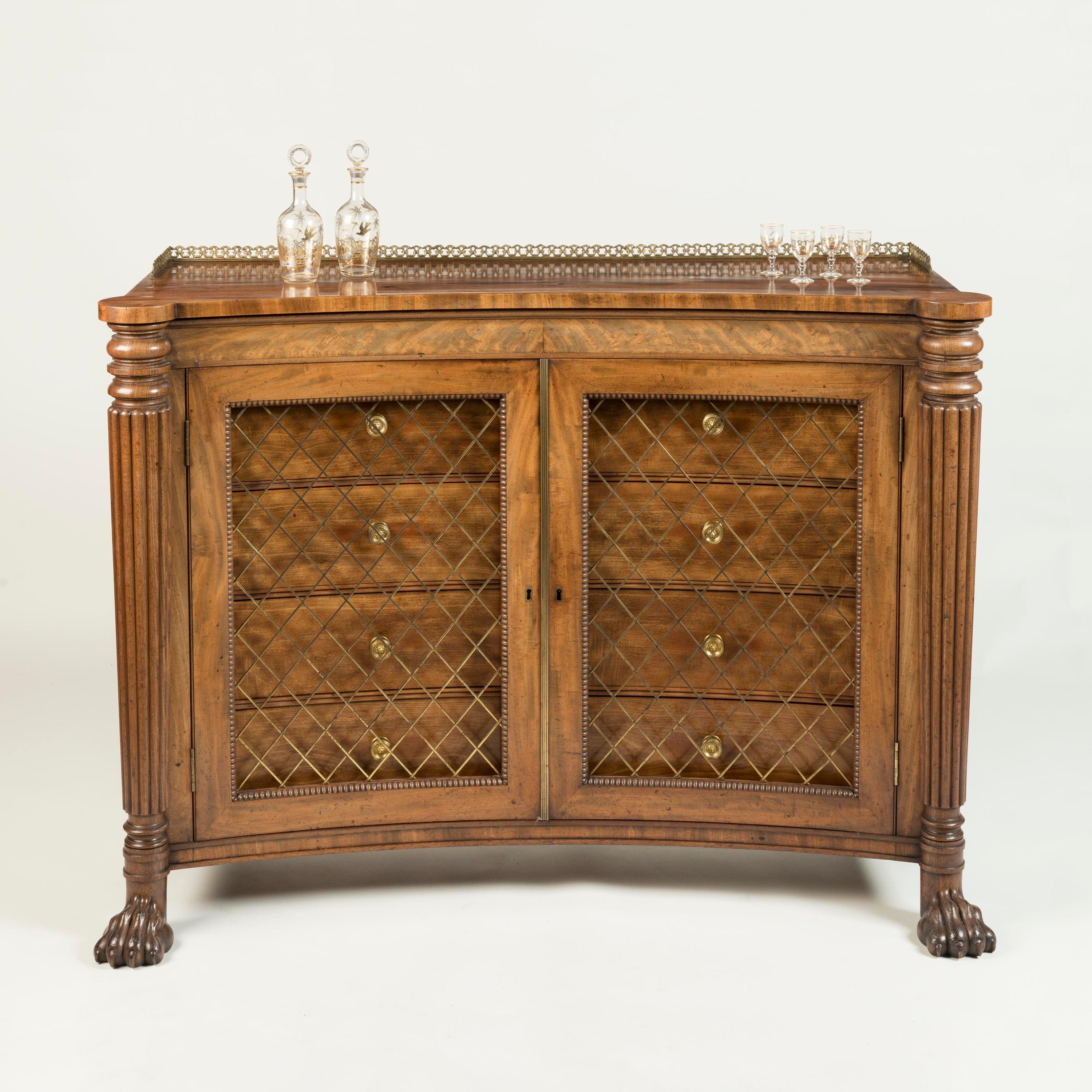 A Rare Regency Concave Side Cabinet
Firmly attributed to Gillows

Constructed from a flamed Cuban mahogany, supported on boldly carved lion's paw feet, the side cabinet of unusual shape with an incurved front, flanked by tapering and reeded columns,