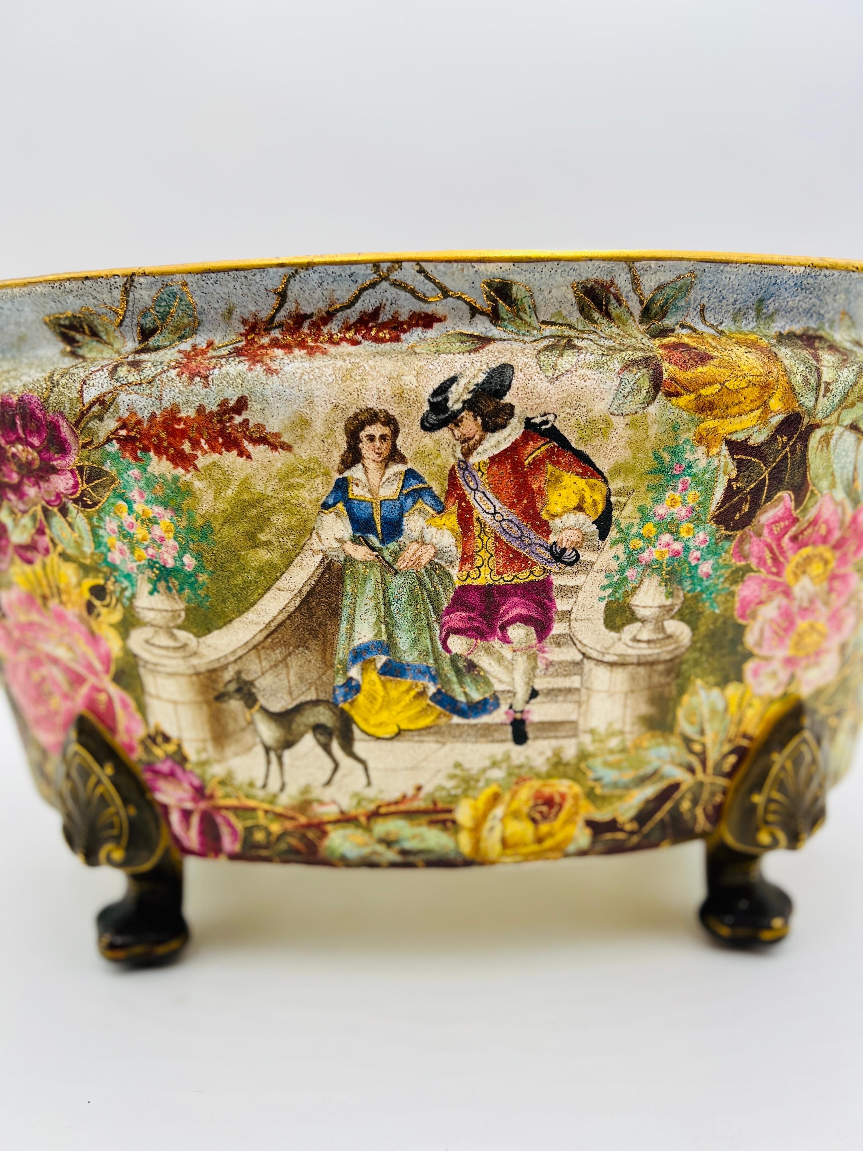 A fantastic heavily decorated tapestry planter or jardiniere incorporating a romantic scene w/ dog to center - gold gilt decoration to handles and feet and a raised enamel decoration across surface. Marked to underside appropriately.