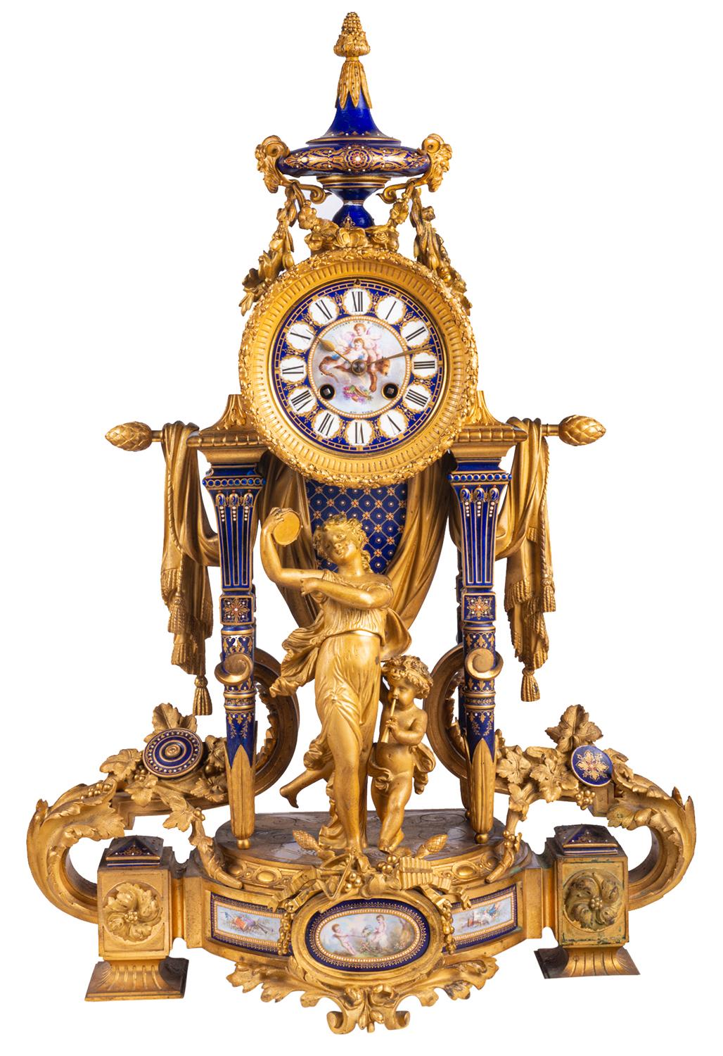 A very fine quality French late 19th century Sevres style and gilded ormolu clock garniture. Having a pair of four branch candelabra, each with ram's head and female mask mounts, drapes and inset Sevres style porcelain plaques with classical hand