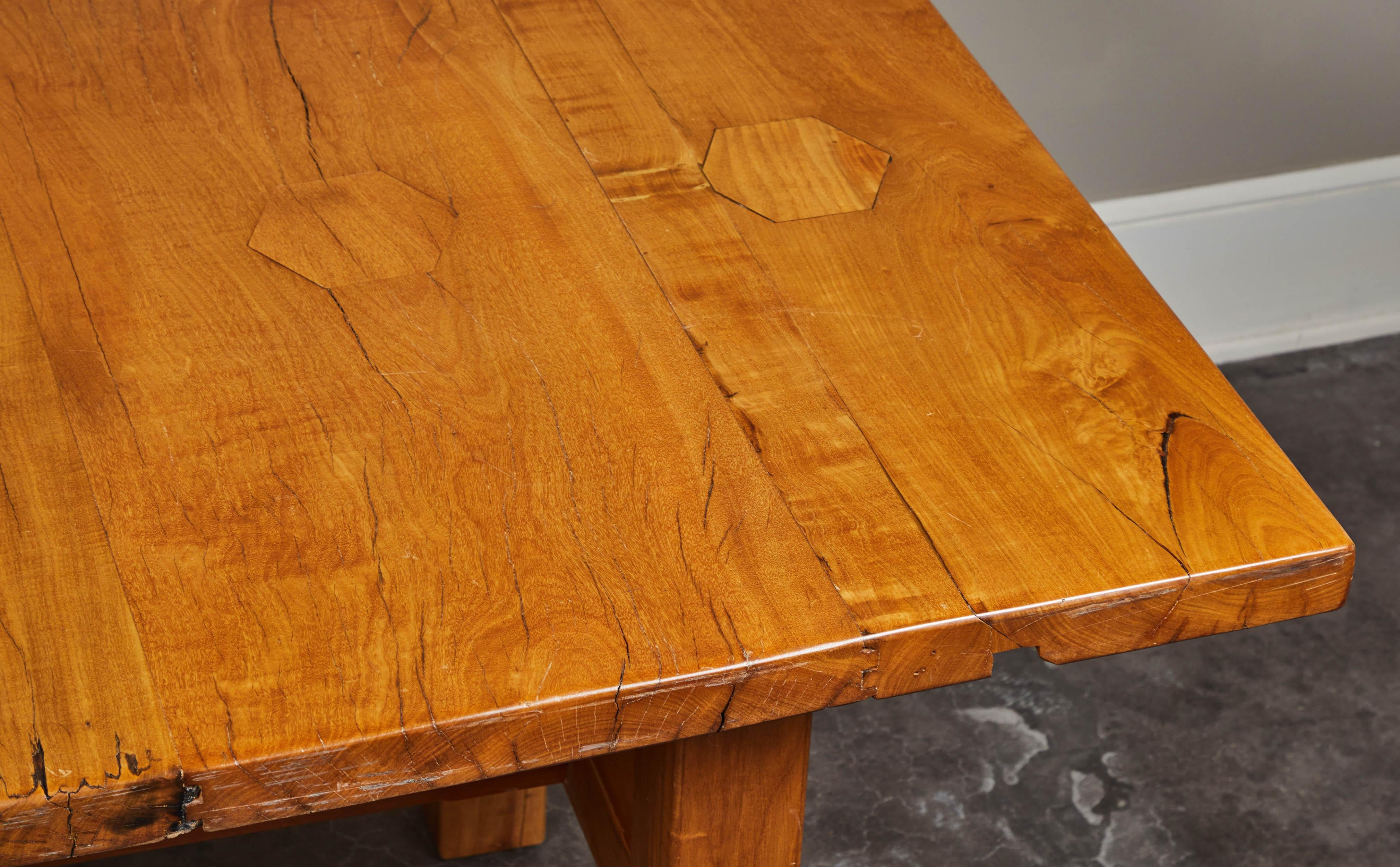 Solid, rare molave wood table, with rustic aging and hexagonal cutouts on the top. Four straight legs and stretcher bar.