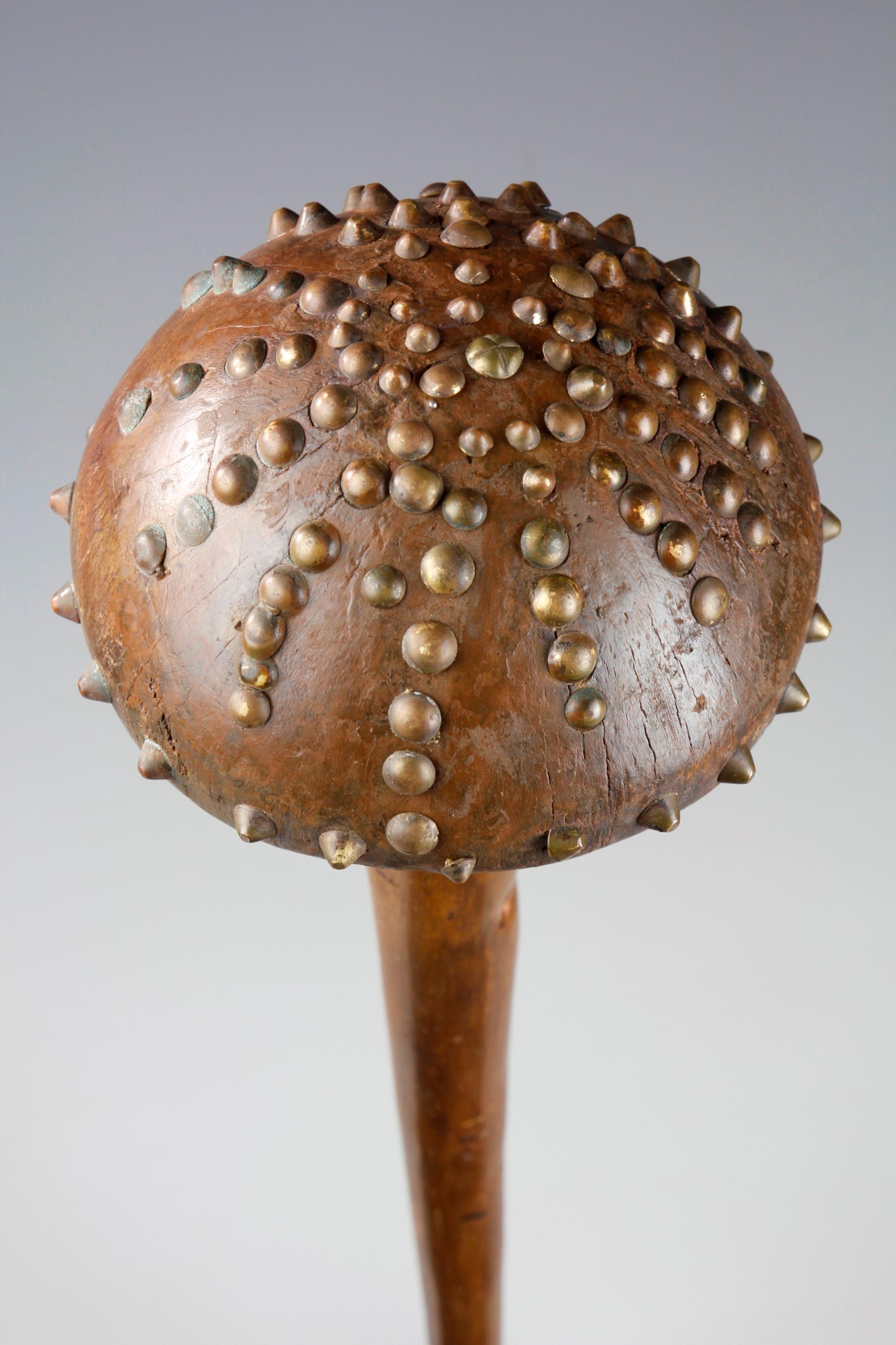The large, mushroom-shaped bulbous head of this rare 19th century Zulu knobkerrie from South Africa has been decorated with an array of early metal tacks. The knobkerrie has been carved into a beautiful tapered form, culminating into a point at its