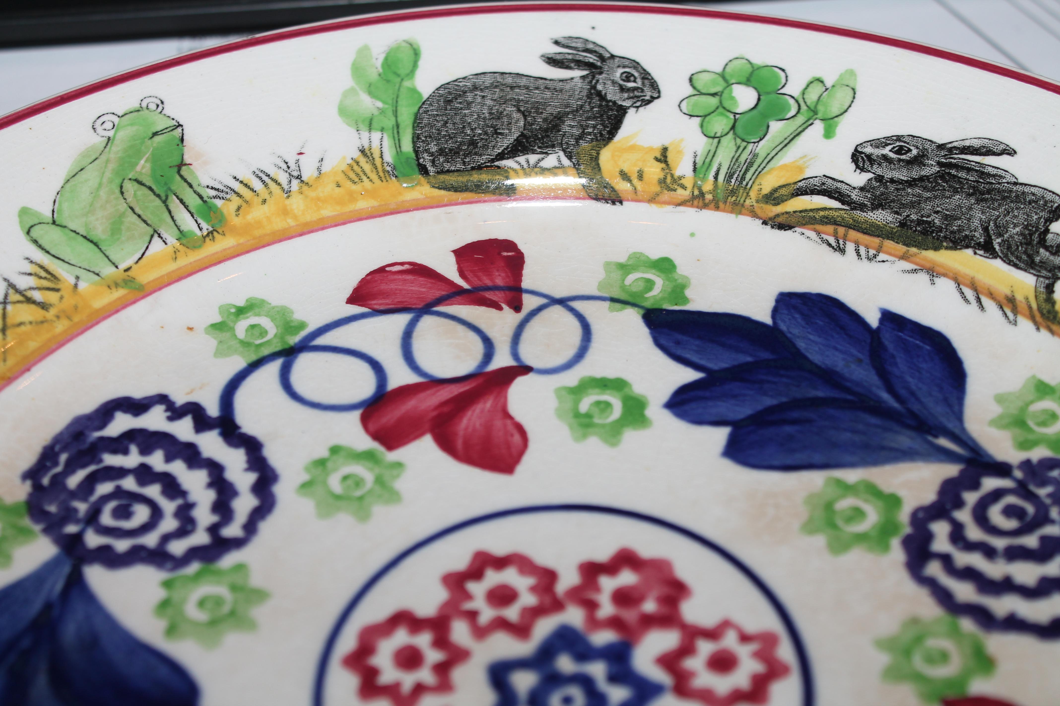This fine folky hand painted stick spatter plate has rabbits running around the border of the plate. The condition is very good with minor crazing from age.
