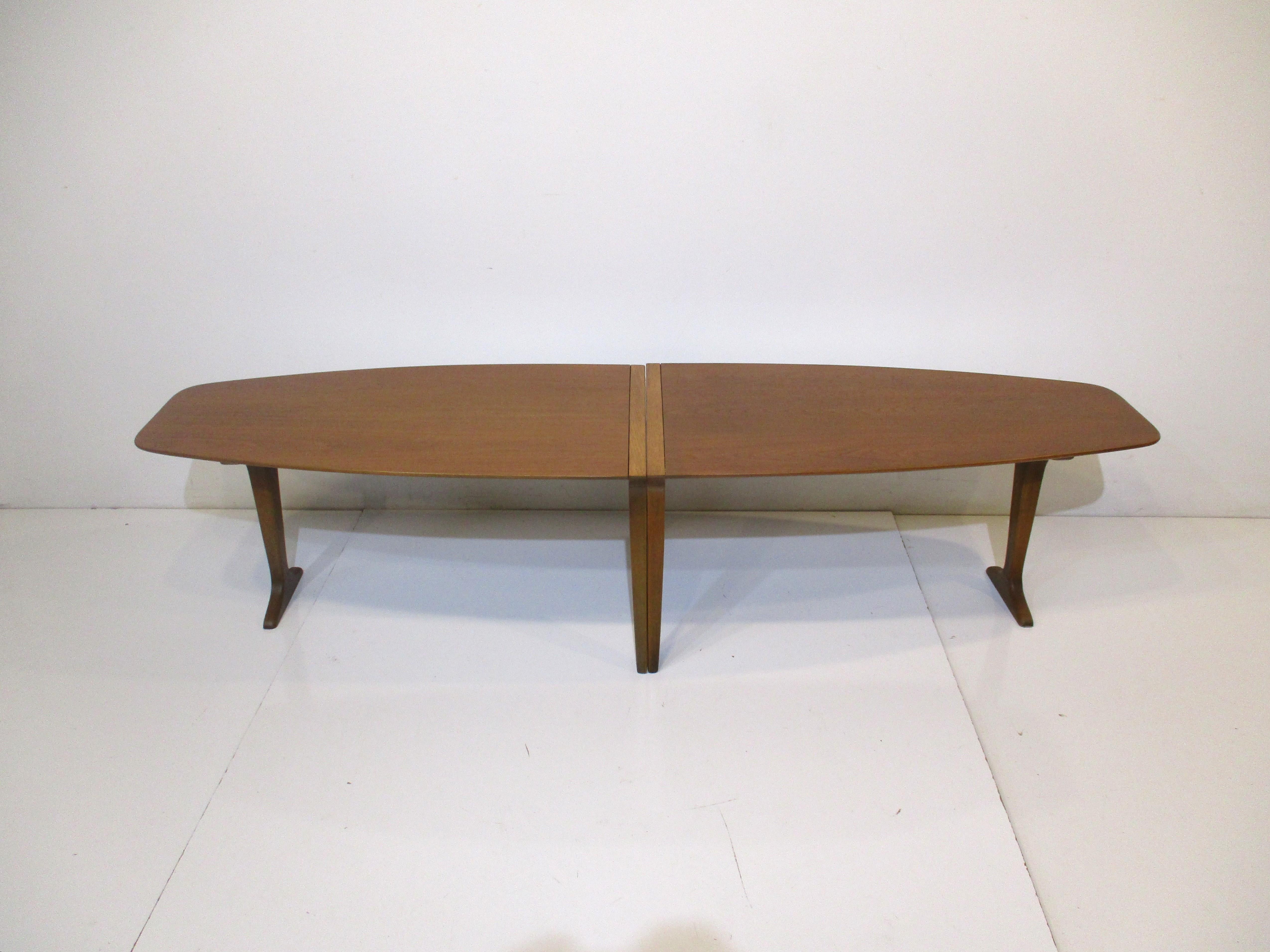 A well crafted two piece mahogany and walnut coffee table with tapered ends and middle legs , the other legs are a T styled design . The top has great graining with nice details a very rare design by John Van Koert manufactured by the Drexel