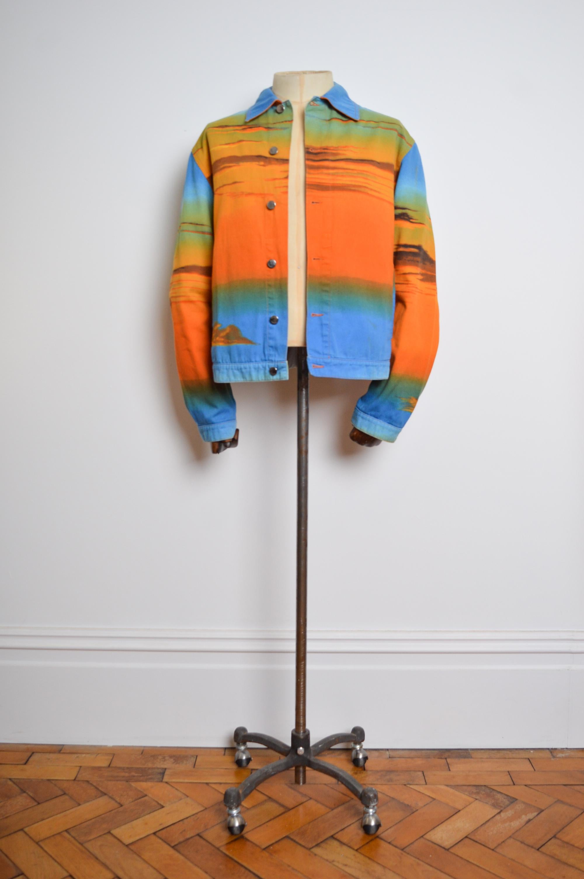 Veste en coton imprimé 'MOSCHINO' du début des années 2000, réalisée en tissu imprimé dans des tons bleus et orange ombrés. 

Nous avons également la chemise et le pantalon assortis disponibles à l'achat séparément. 

FABRIQUÉ EN ITALIE.  