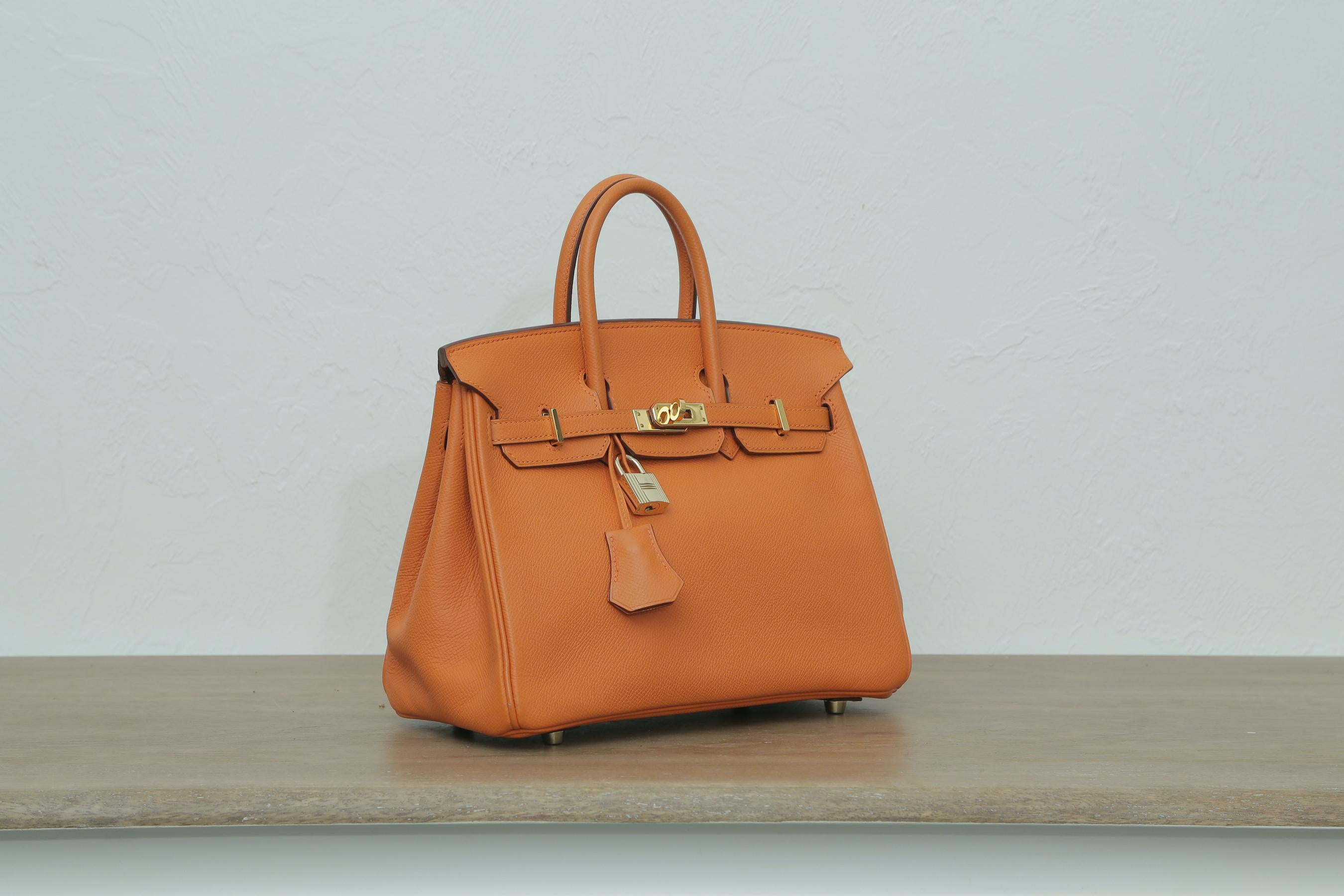 2006s Hermes Birkin 25 Orange with Gold Hardware.
 J in a square. The bag come with the original duster and box.