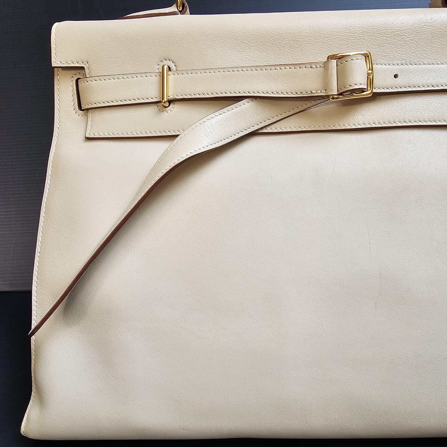 Rare Kelly flat 35 in parchemin swift leather with gold hardware. Beautiful twist to a classic bag. Slight storage marks to the bag overall. Faint spot marks on the front body leather but blends in well with the bag color. Lining shows some dirt