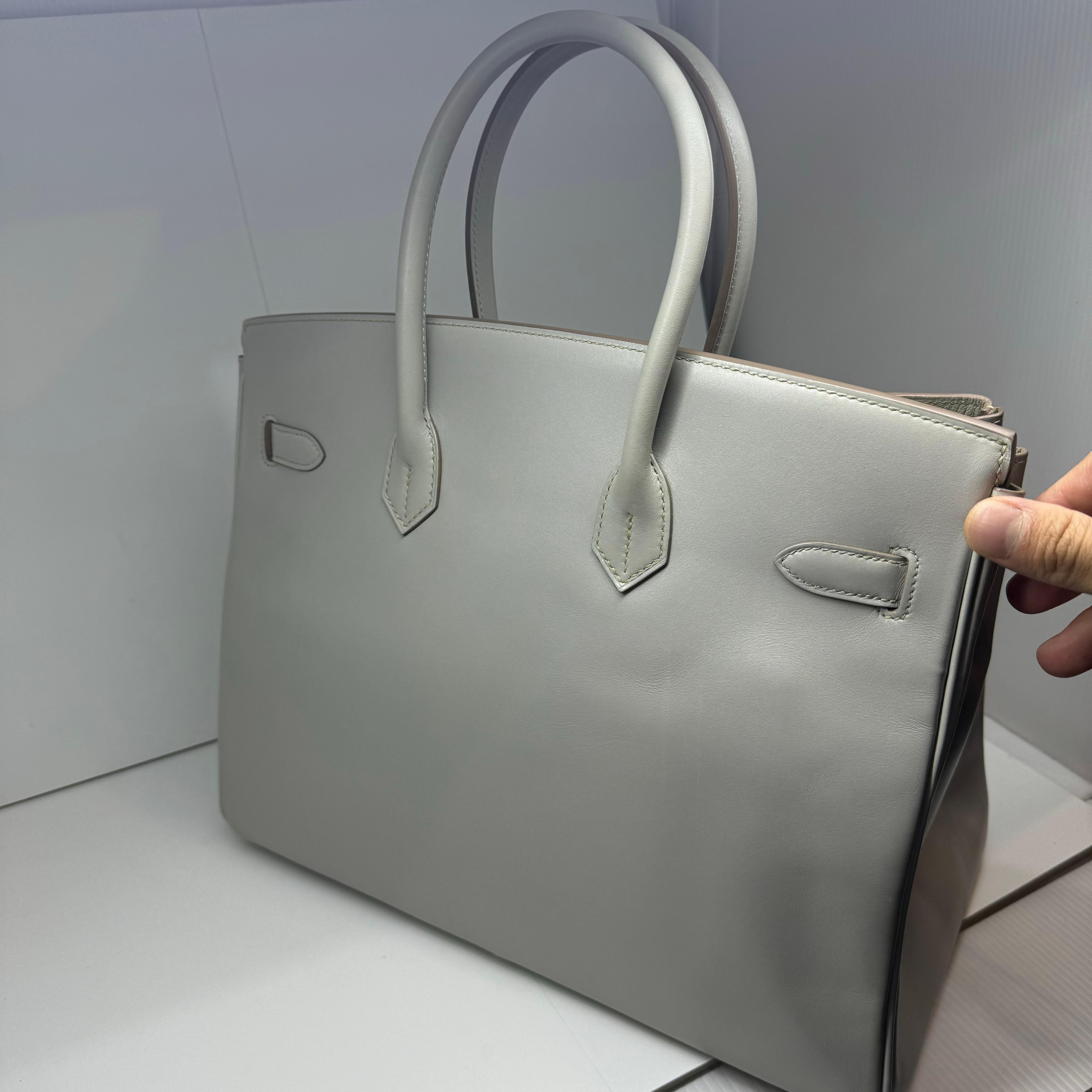 Birkin 35 in swift gris perle leather with guilloche palladium hardware. Slight scratching and scuffing throughout due to the nature of the leather, mostly visible on the flap top and bottom area. The gris perle in tadelakt leather shows a metallic