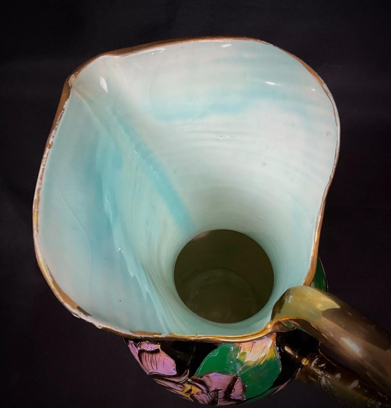 Cette exquise et rare grande carafe en céramique, signée par Vallauris, présente un magnifique motif de rose peint à la main qui illustre l'art de la céramique française du milieu du XXe siècle. Ses couleurs vibrantes et sa décoration détaillée en