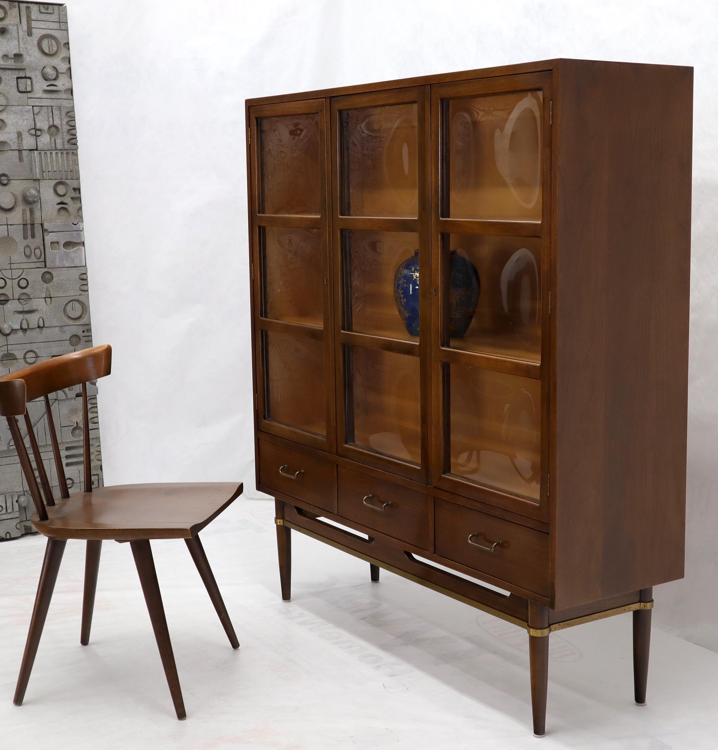 Mid-Century Modern walnut bubble glass display cabinet. Stunning condition vitrine with three drawers on the bottom standing on tapered legs with brass accents.