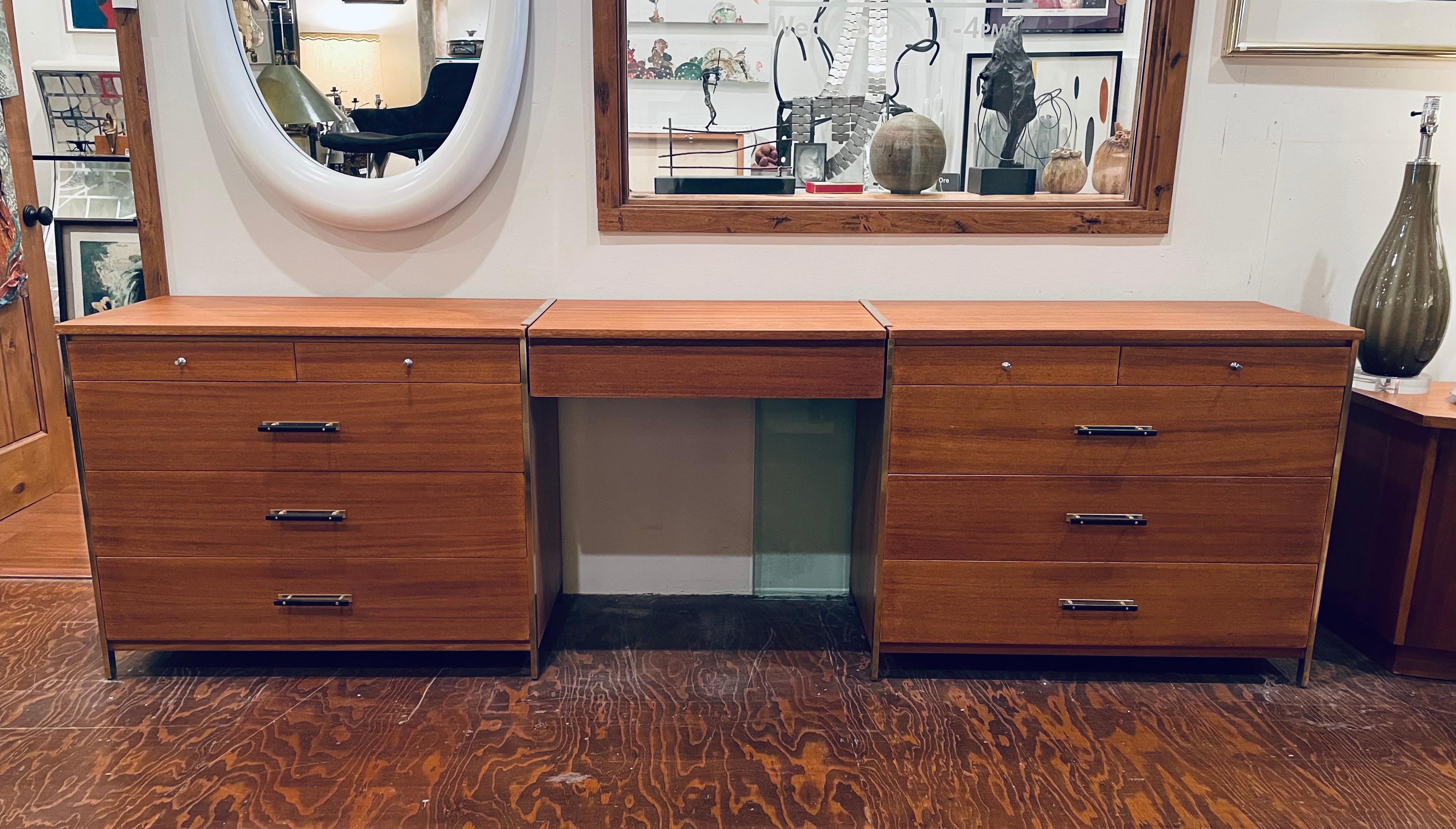 A very rare set of 3 pieces vanity and 2 dressers designed by Paul Mccobb for the Calvin Group, circa 1950s with brass legs and brass details the vanity sits in the middle of the 2 dressers has a mirror and the front folds down as shown the set of 2