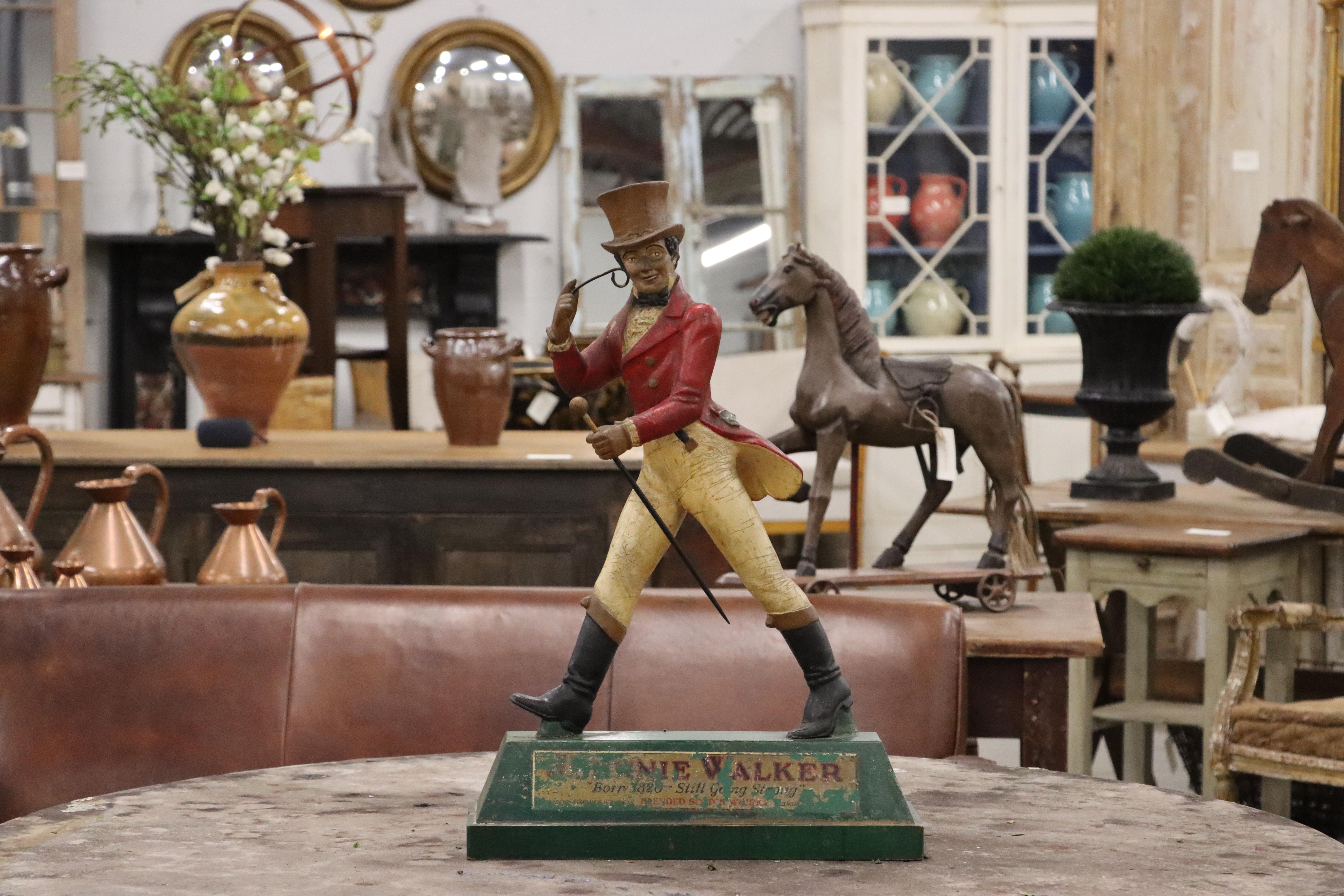 This 30-inch Johnnie Walker Striding Man statue is quite rare as this size was not typically mass-produced or widely available for public sale.

The design of the iconic cheerful dandy Striding Man logo is attributed to a British illustrator named