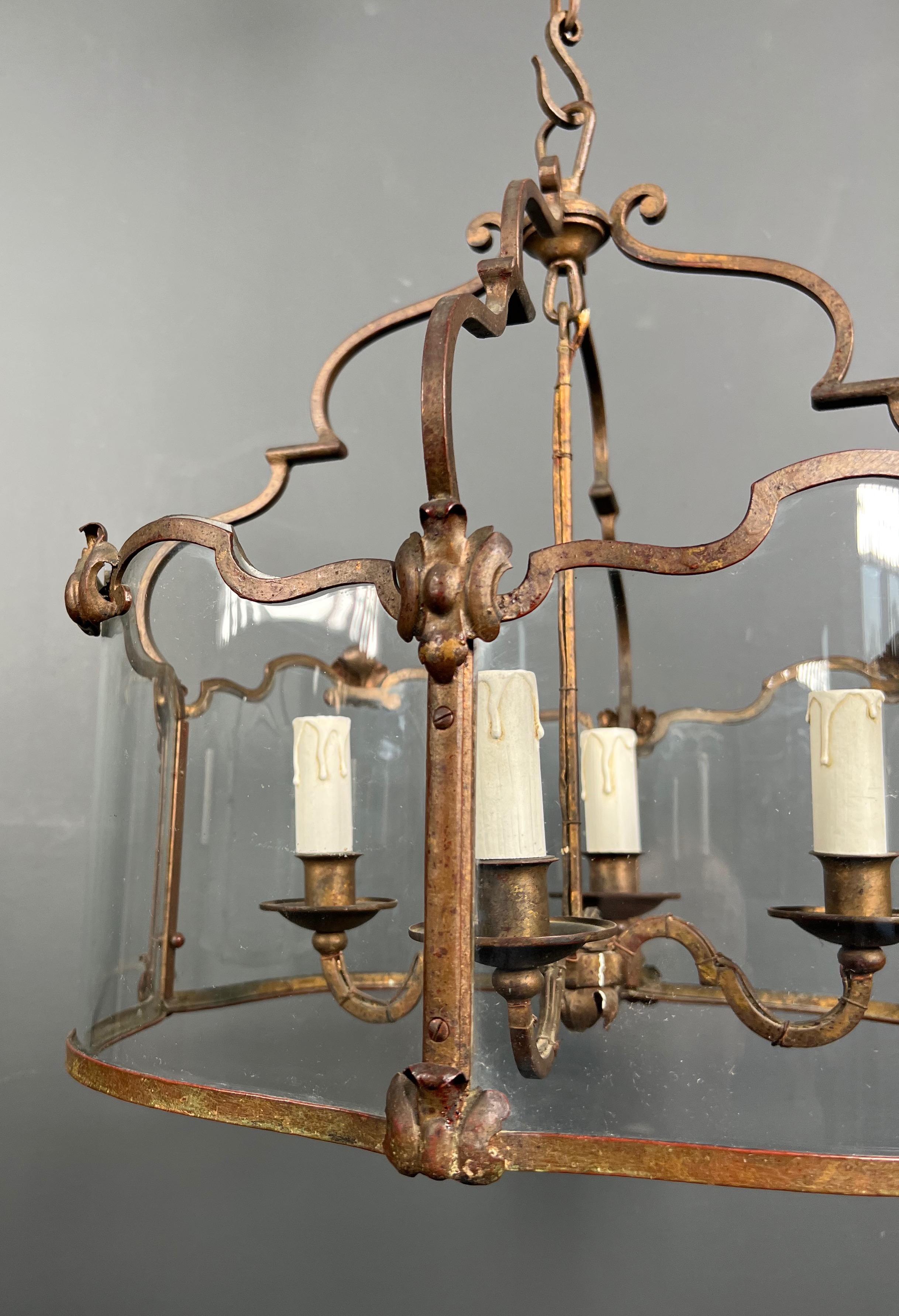 Milieu du XXe siècle Rare lanterne à 4 lumières en fer forgé battu doré avec verres incurvés. Travail français. en vente