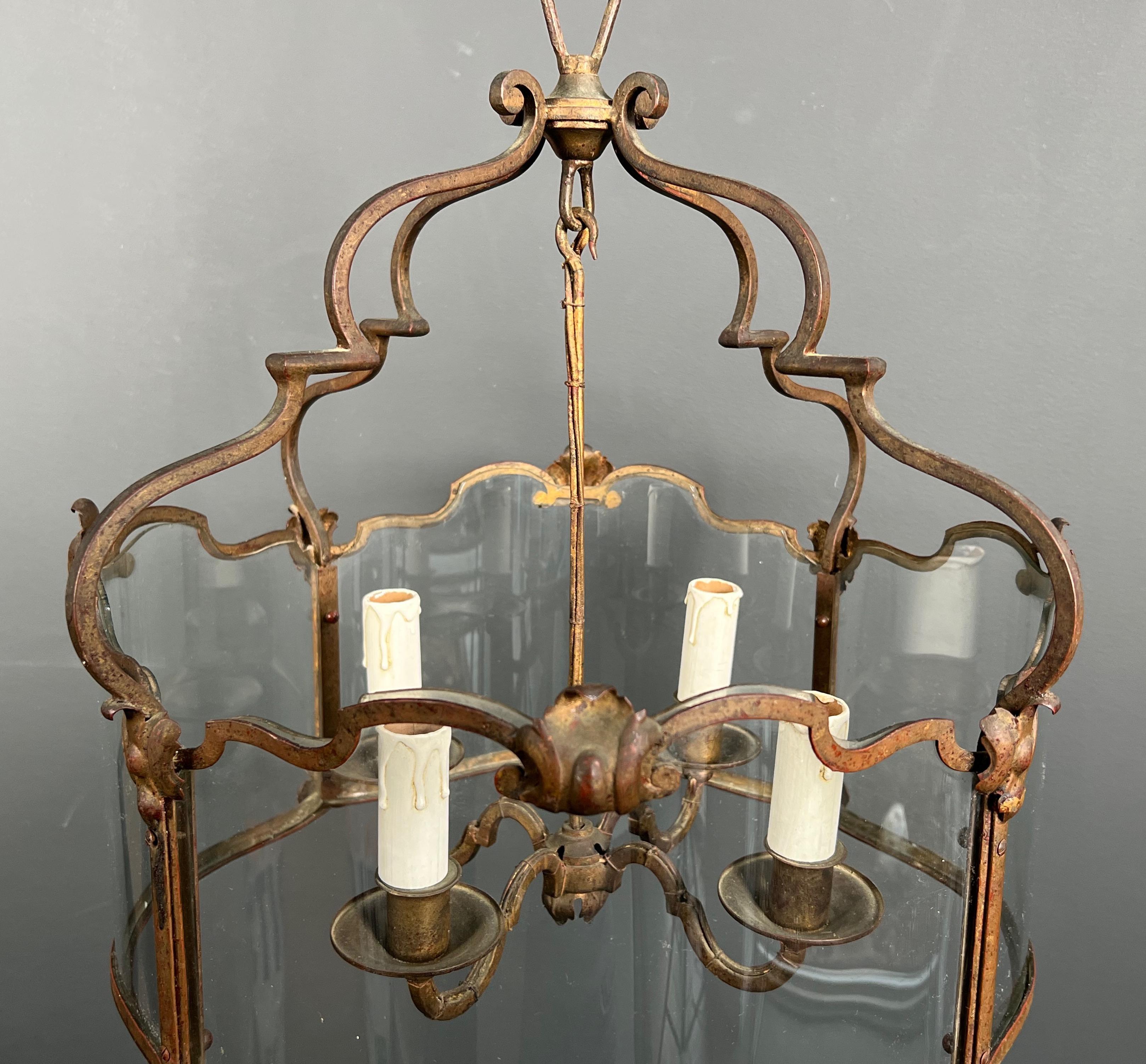 Verre Rare lanterne à 4 lumières en fer forgé battu doré avec verres incurvés. Travail français. en vente