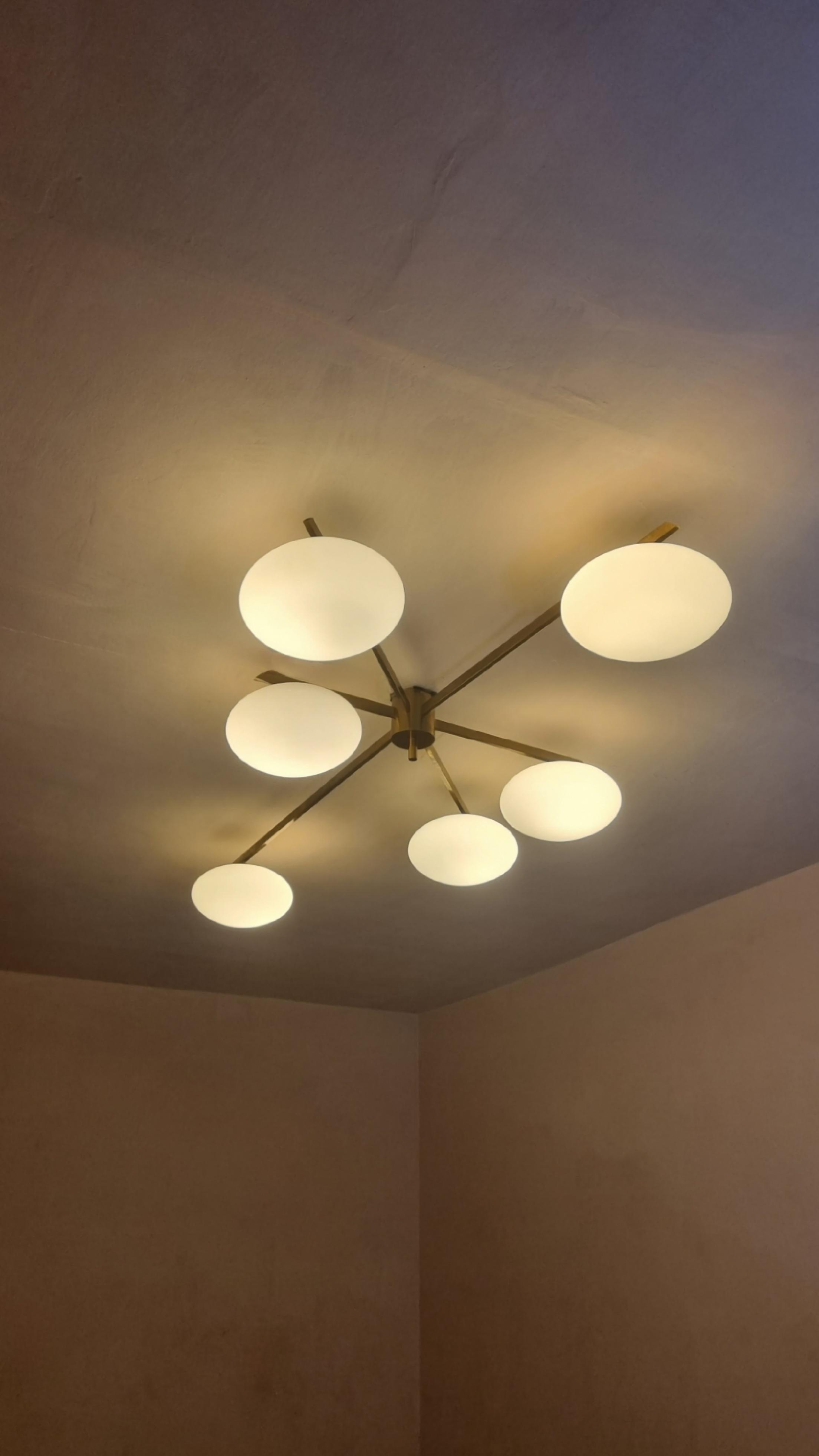 Rara lampada a soffitto 6 lune disegnata da Angelo Lelii per Arredoluce, 1961. 
Struttura in ottone, diffusori in vetro duplex opal bianco, 6 punti luce, etichetta della manifattura, eccellenti condizioni.
Su richiesta del cliente è disponibile il