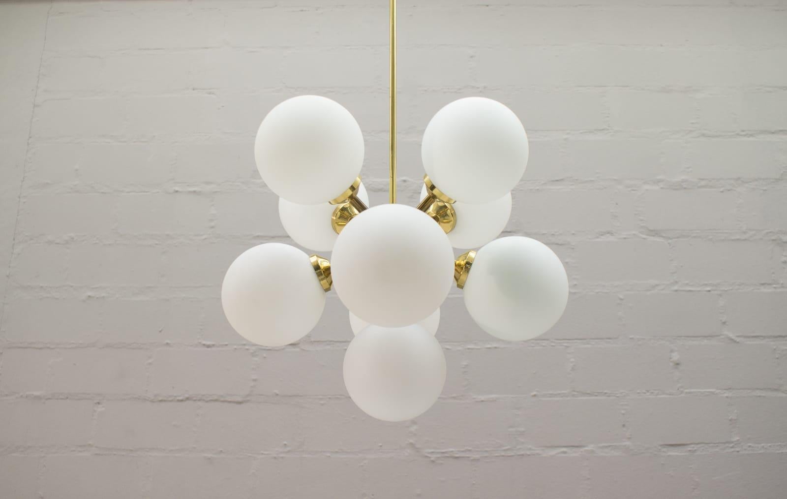 This vintage ceiling lamp features twelve milk glass balls with E14 bulb sockets and a gilded frame.

Very elegant and decorative.