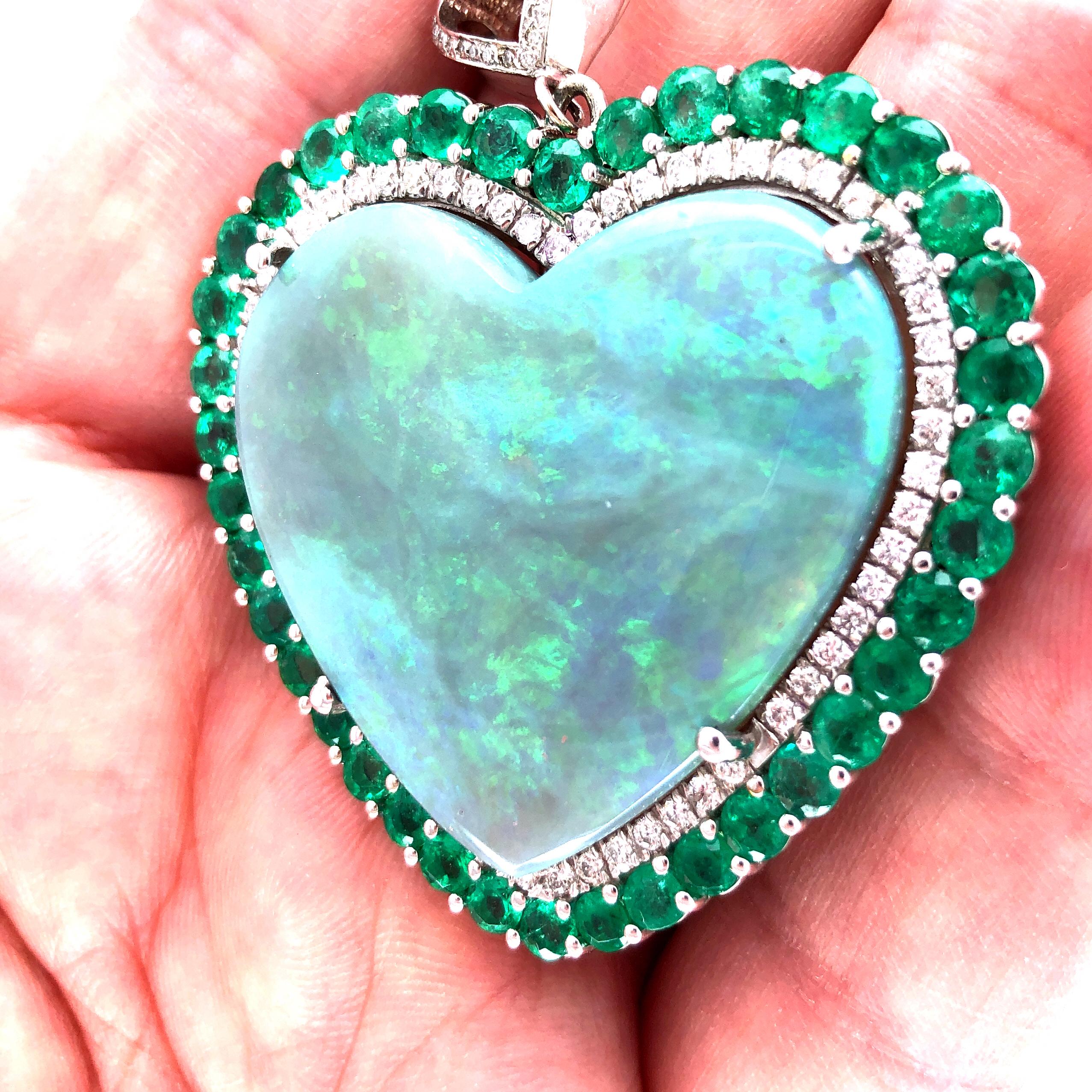 Offered here is a rare natural earth mined hearth shaped Black Opal, weighing 65 carats.
Opal is set within a halo set with natural earth mined diamonds then again framed with natural earth mined green Colombian emeralds.
Diamonds: sparkly bright