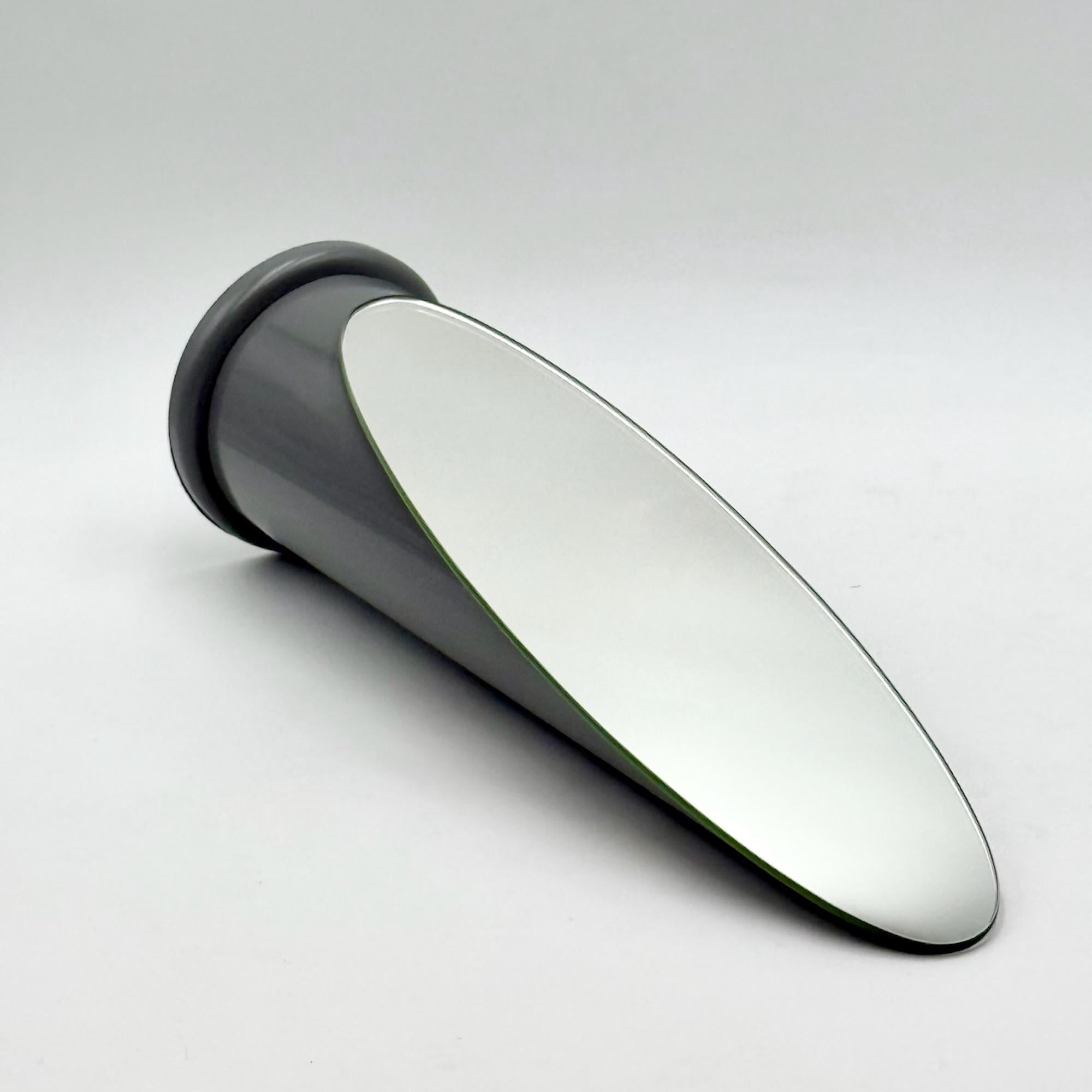 A rare and lovely table mirror with the timeless ‘Lipstick’ design created by Rodolfo Bonetto and produced in Italy in the 70s. 

This design classic is made of a round plastic structure with lacquered grey finish. The vertical shape resembles a