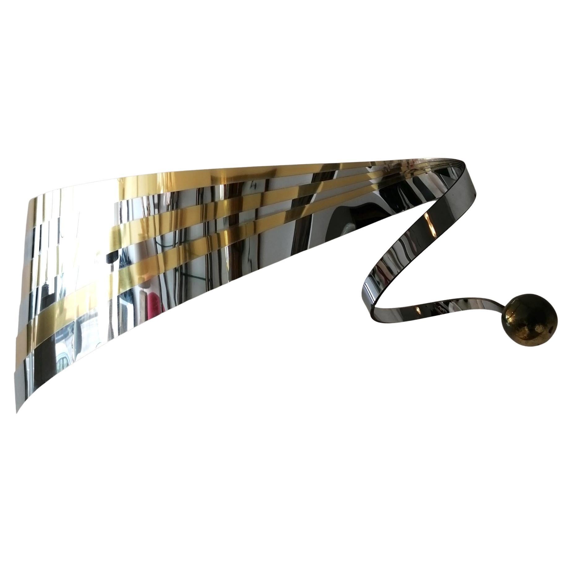 Rare 1989 gold & chrome undulating ribbon wall sculpture by Curtis Jere, USA. Signed & dated. Has 2 inbuilt hangers on the back.

Dimensions: Length 130cm, 59cm high, 19cm deep.