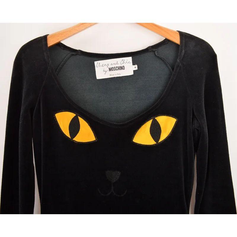Incredible Vintage early 1990's Moschino black velvet 'Cheap & Chic' label body con dress, featuring novelty Cat face appliqué to the front. 

MADE IN ITALY !

Features:
Long sleeves
Fitted shape
Rounded neckline

85% Cotton / 15%
