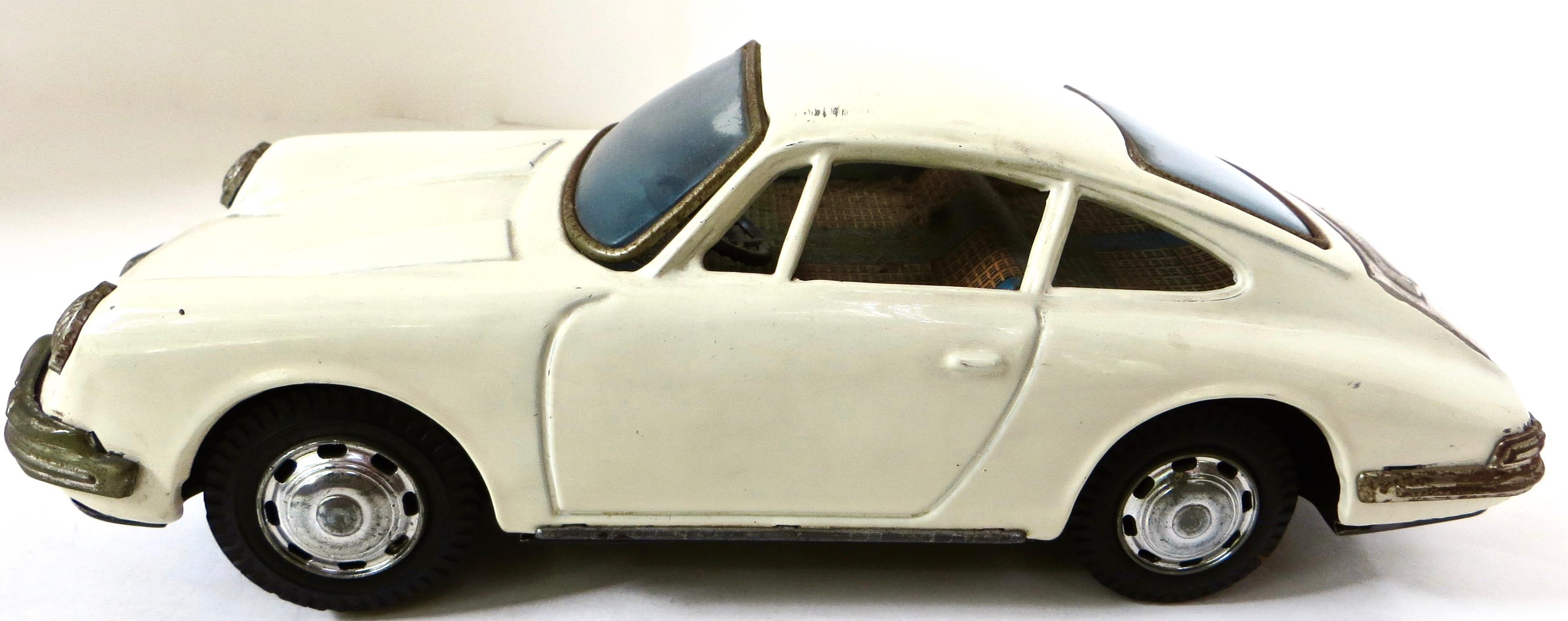 Offered here is a whitish/cream colored friction tin toy 911 Porsche circa 1960's, marked at the bottom; 